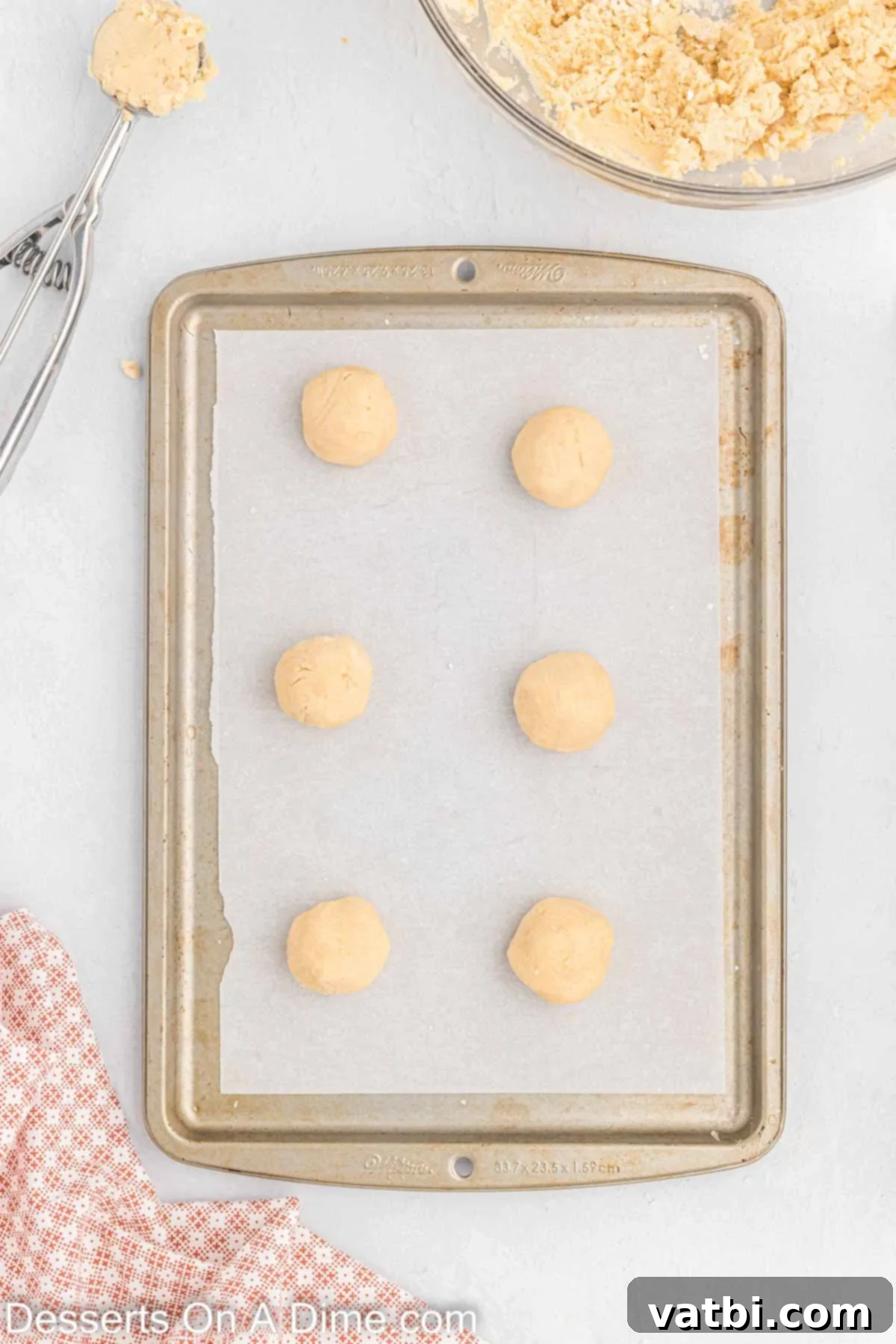 Cookie dough balls placed on baking sheets.