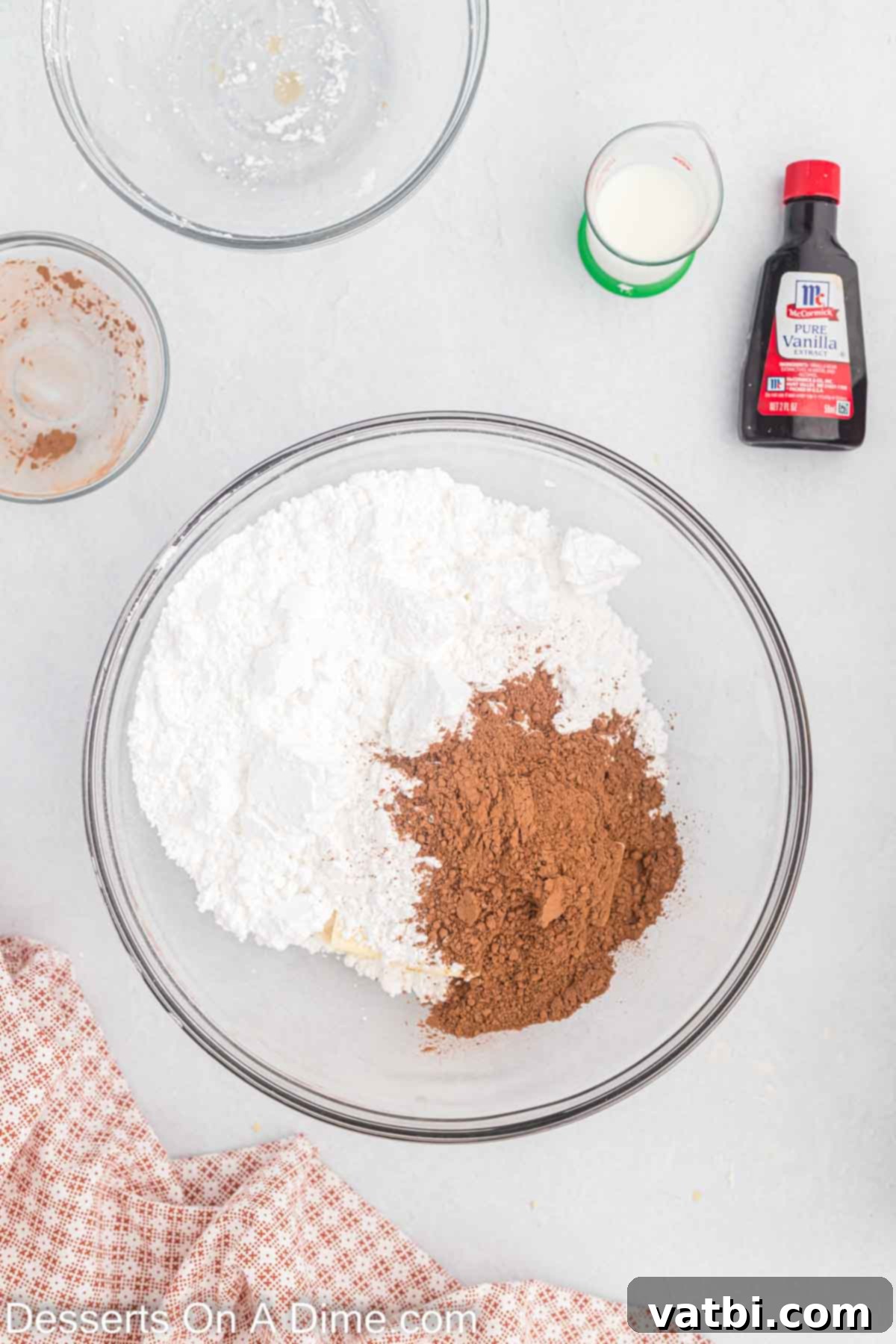 Dry ingredients combined in a bowl to make chocolate frosting.