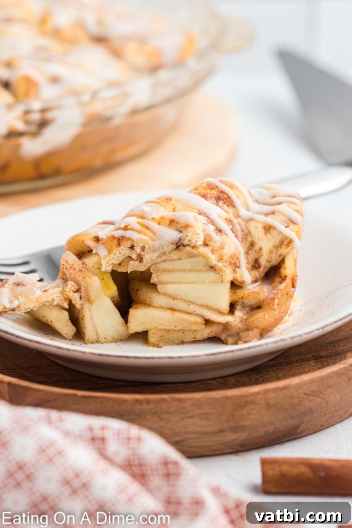 Delicious Cinnamon Roll Apple Pie 10 A serving of cinnamon roll apple pie on a plate with a fork.