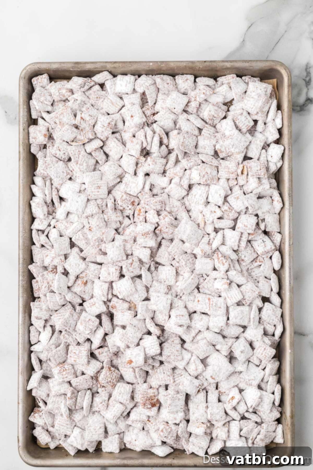 Perfect Harvest Puppy Chow Recipe 11 Chex cereal cooling on a baking sheet.