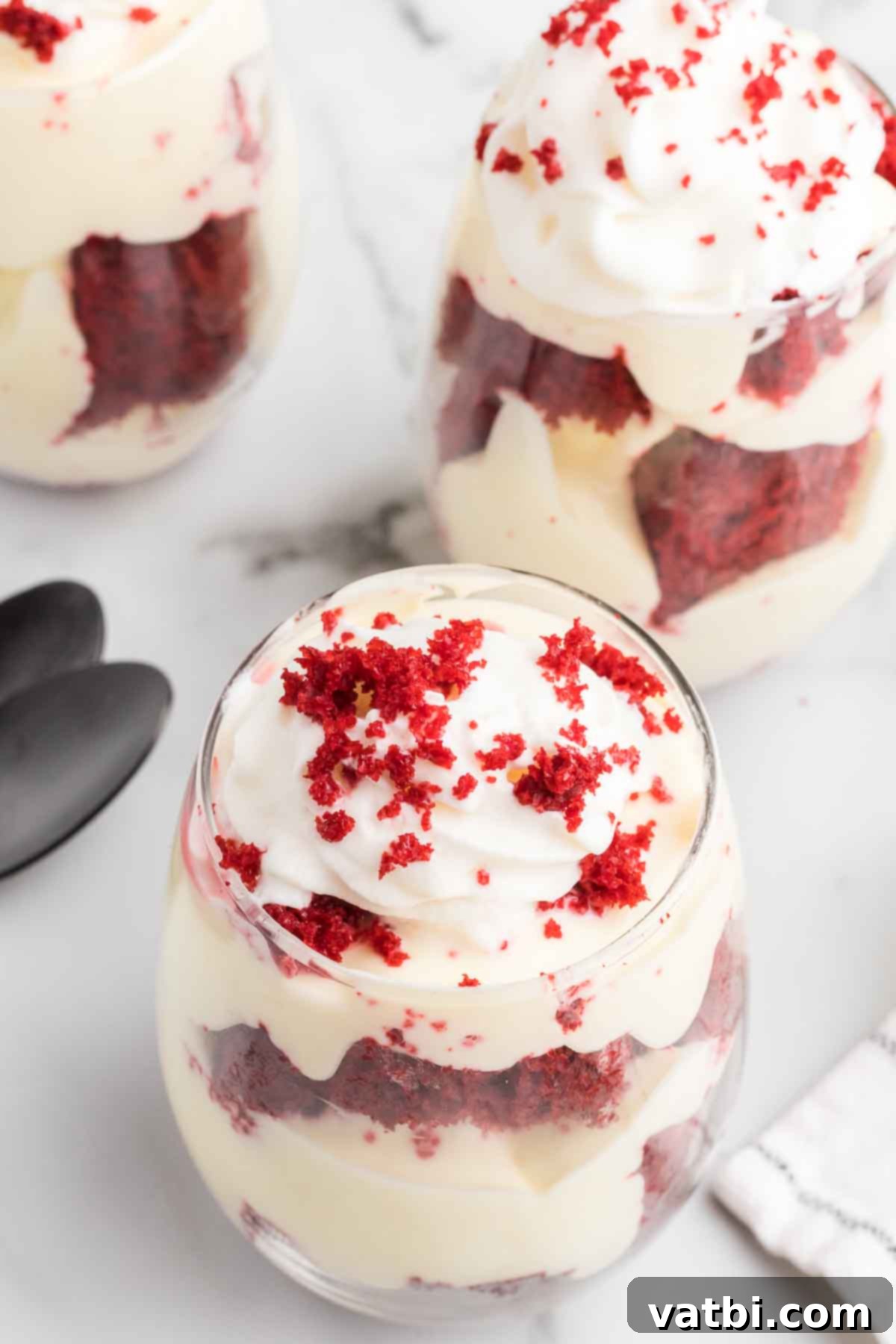 Red Velvet Dream Cups 11 Individual Red Velvet Trifle Cups with visible layers of cake, pudding, and whipped cream, topped with red velvet cake crumbs.