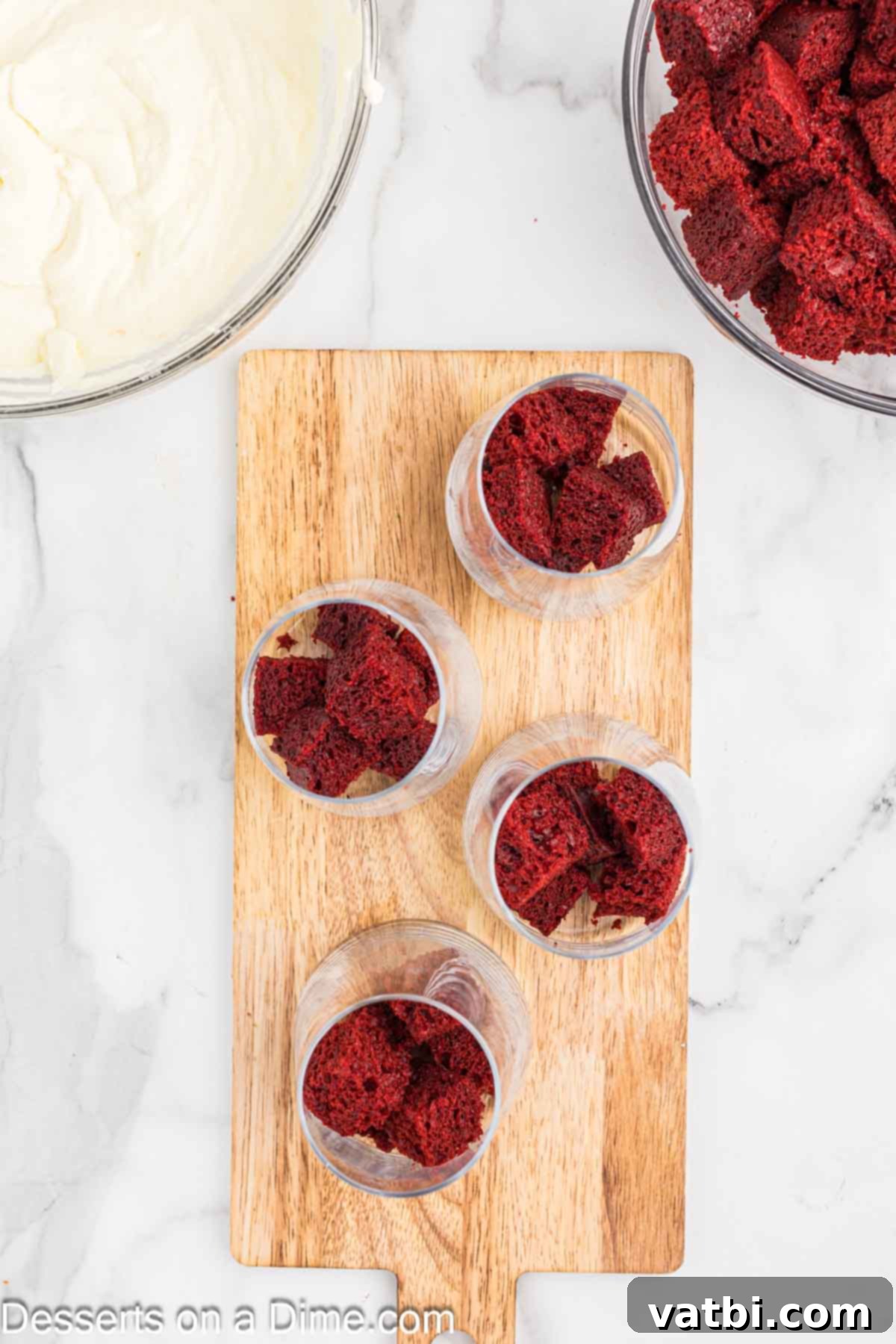 Red Velvet Dream Cups 10 Red velvet cake cubes layered at the bottom of a clear dessert cup, ready for the next layer.
