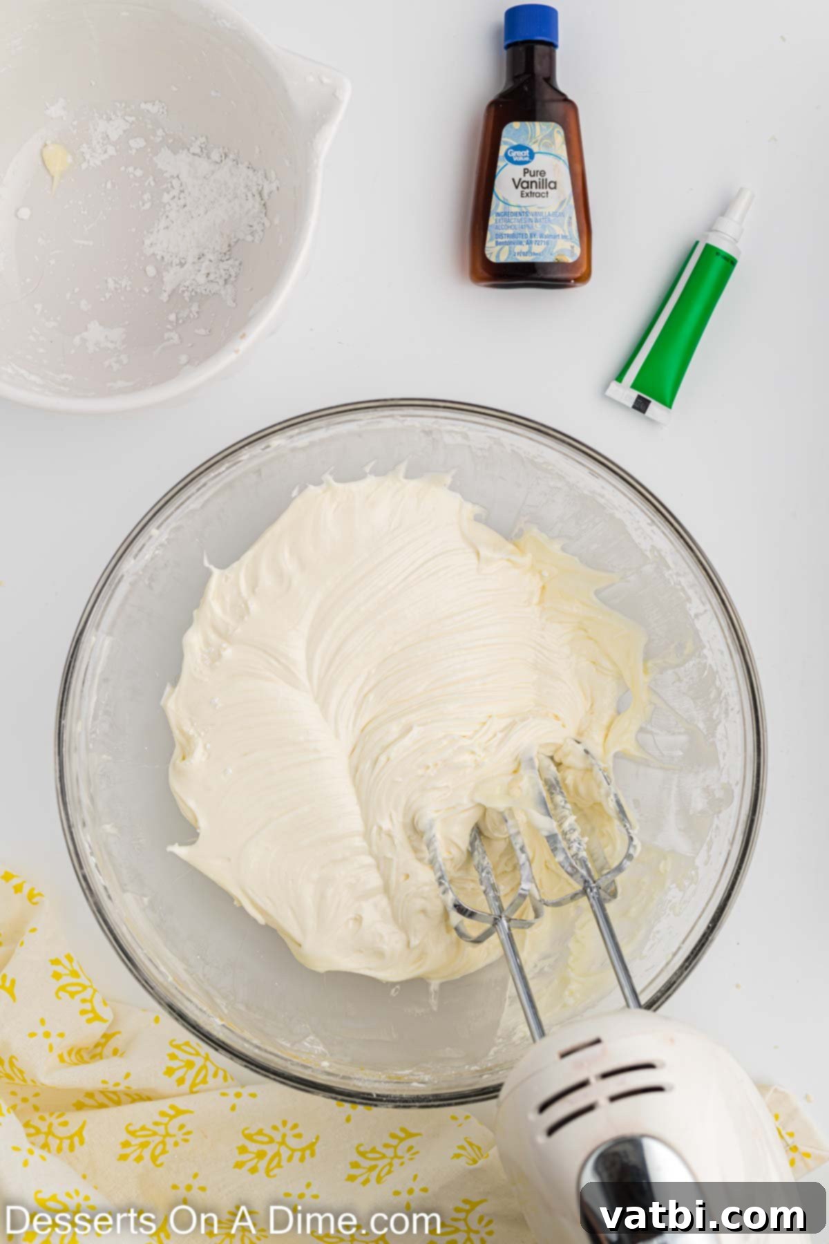 Festive Christmas Tree Sugar Cookies 9 Powdered sugar being carefully and gradually added to the cream cheese and butter mixture in a mixing bowl, ensuring smooth incorporation for the frosting.
