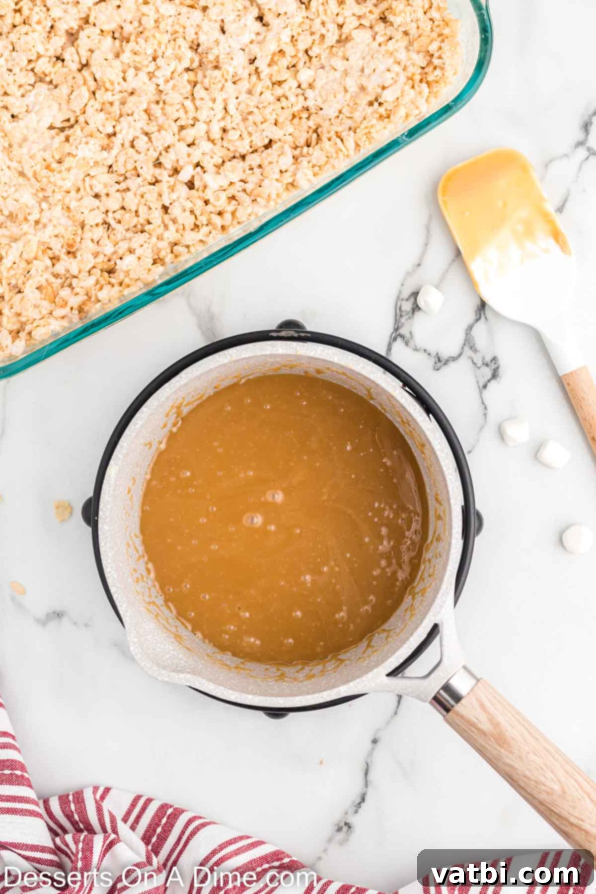 Homemade caramel sauce simmering and thickening in a saucepan, showing a rich, golden color.