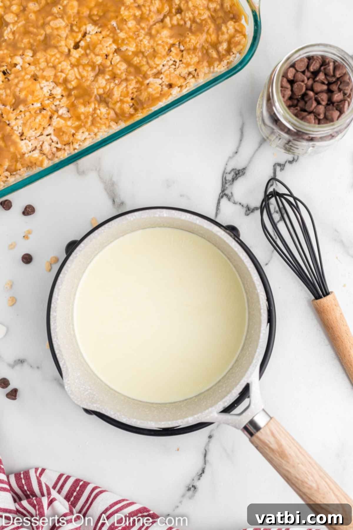 Heavy whipping cream heating in a separate saucepan, showing small bubbles around the edge, indicating it's almost boiling.