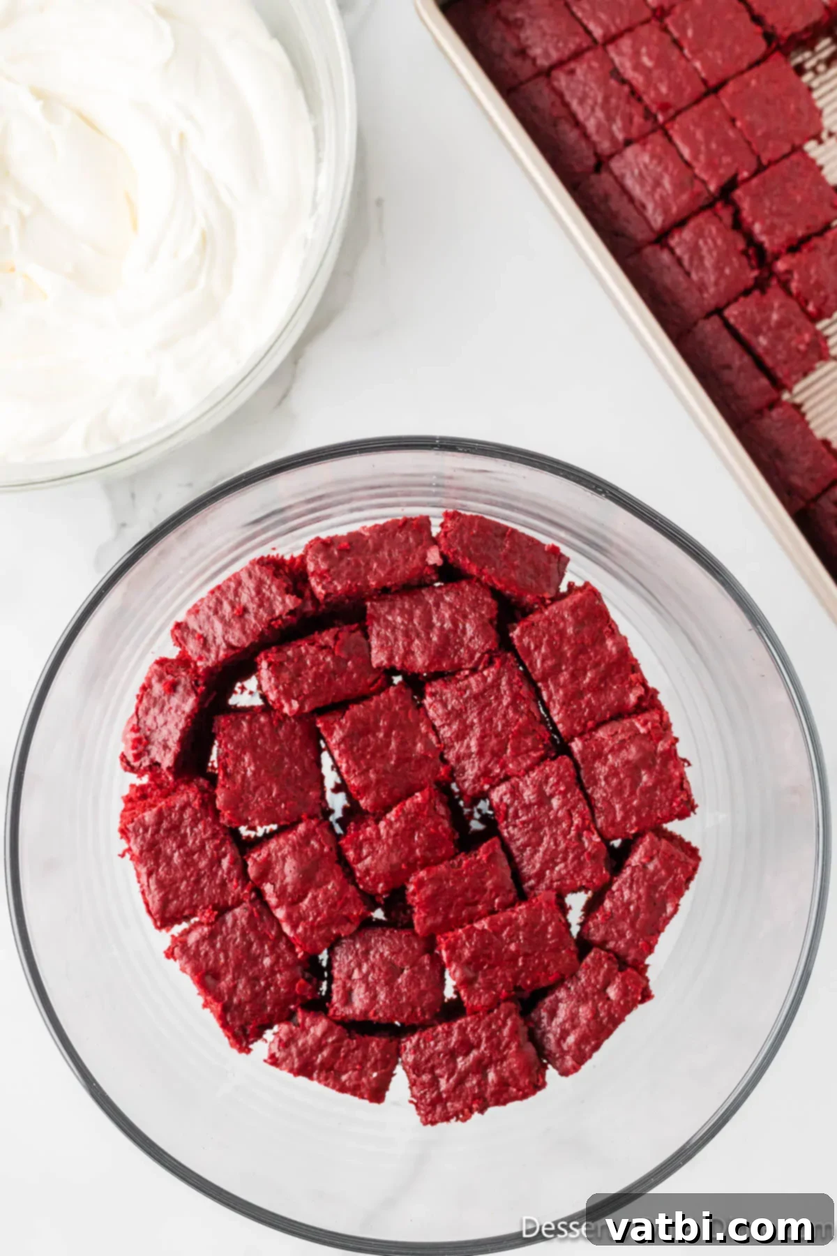 Crimson Velvet Trifle 12 First layer of red velvet cake cubes placed at the bottom of a trifle dish.