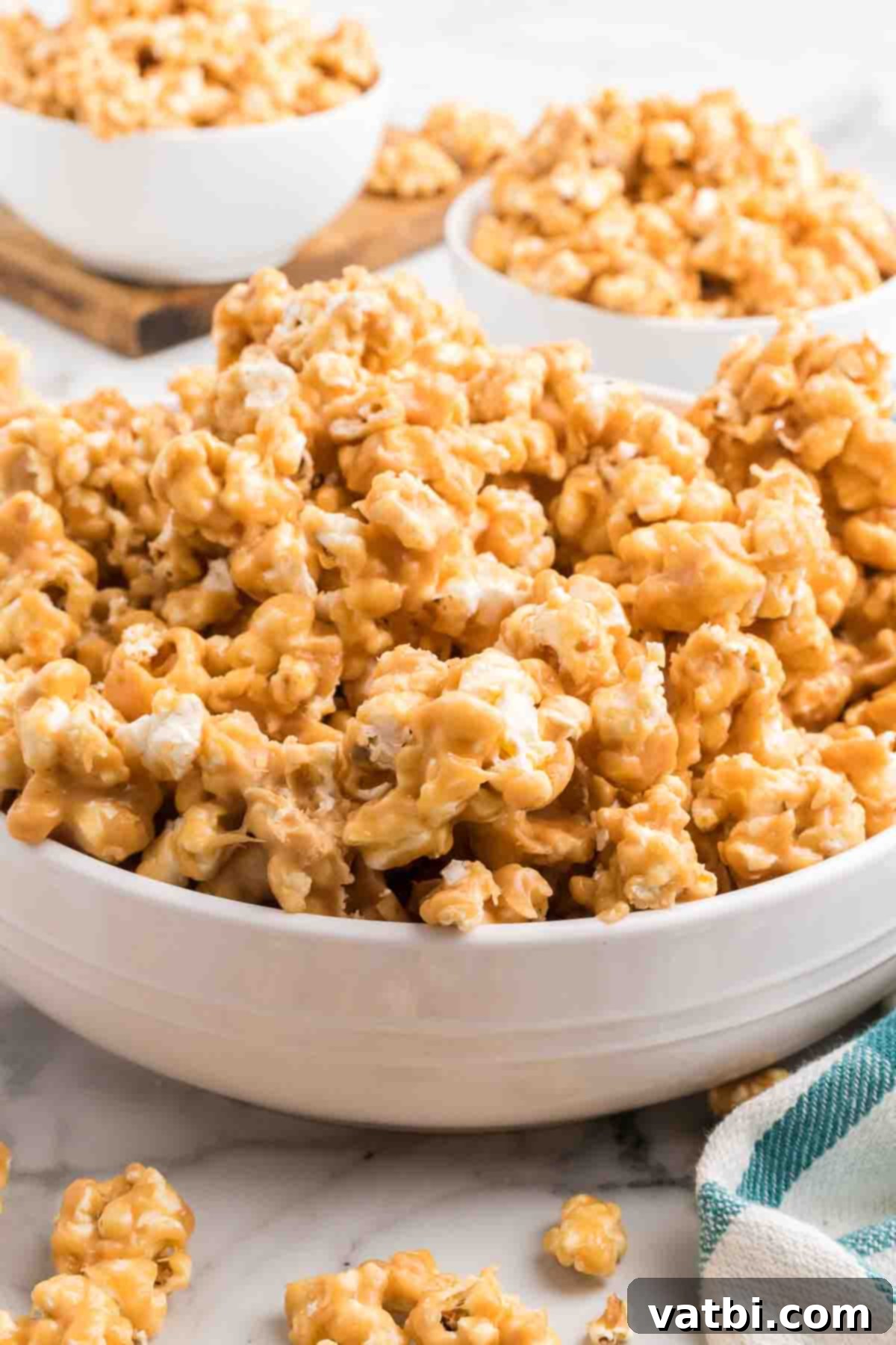 Close-up of peanut butter popcorn in a bowl, showing the rich, golden coating.