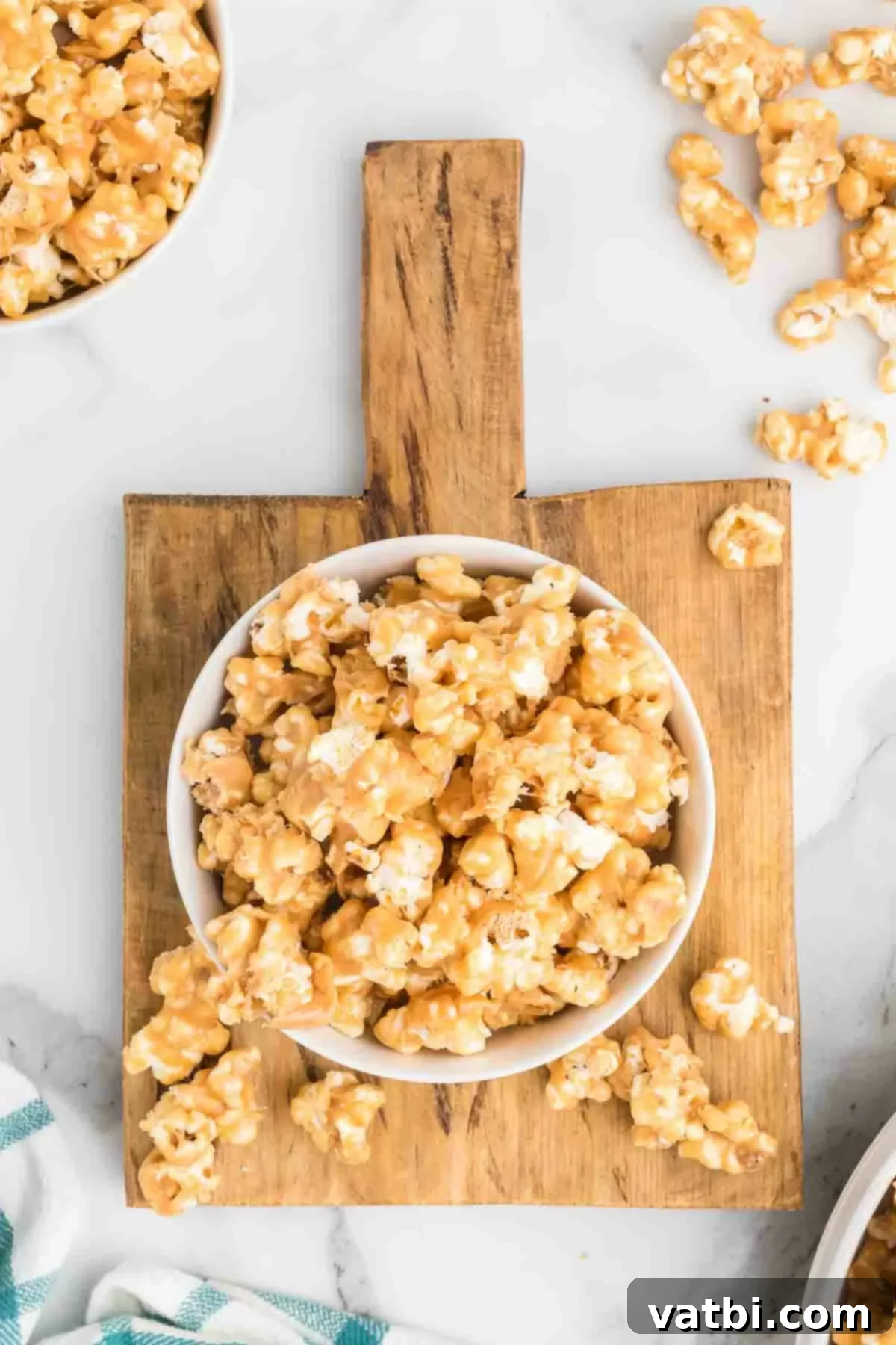 A large serving bowl full of golden, delectable peanut butter popcorn.