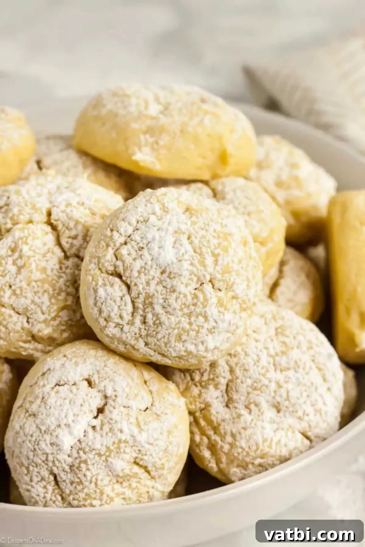 If you love cheesecake, you're going to go crazy over Cream Cheese Cookies Recipe. Cheesecake cookies recipe is rich and creamy for the best dessert. Cream Cheese Cookies topped with powdered sugar in a large white bowl.