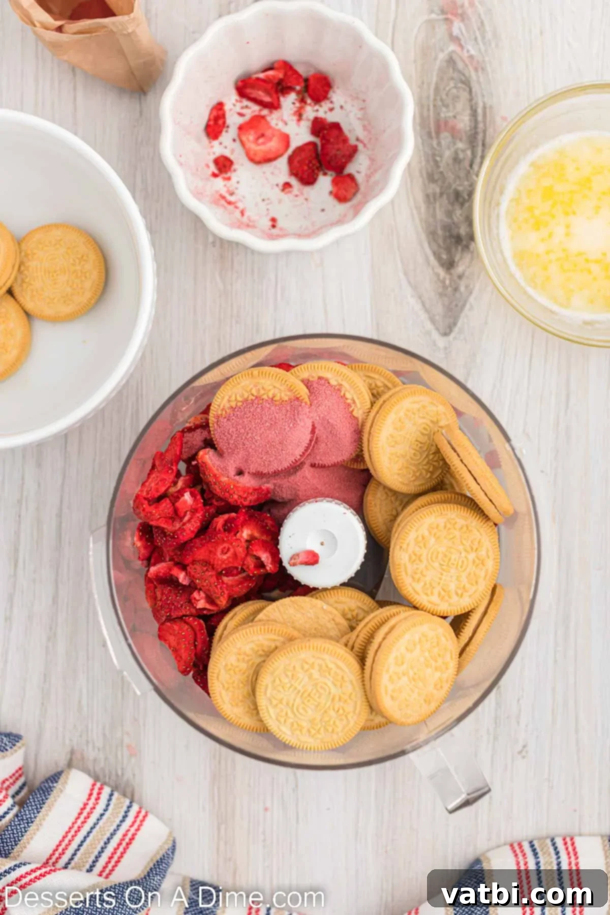 Strawberry Crunch Poke Cake 7 Golden Oreos and freeze-dried strawberries in a food processor, ready to be blended for the topping.