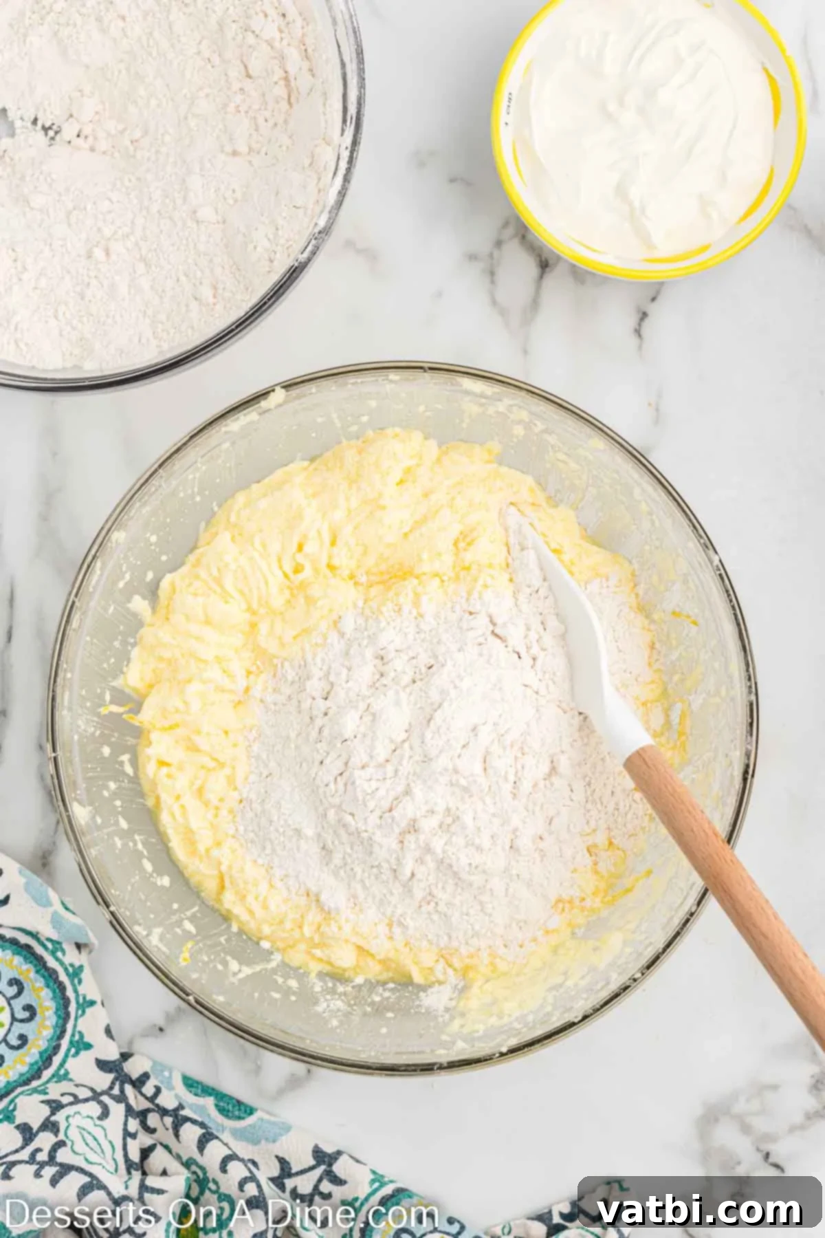 Wet and dry ingredients partially combined in a bowl, illustrating the alternating additions for optimal batter consistency.