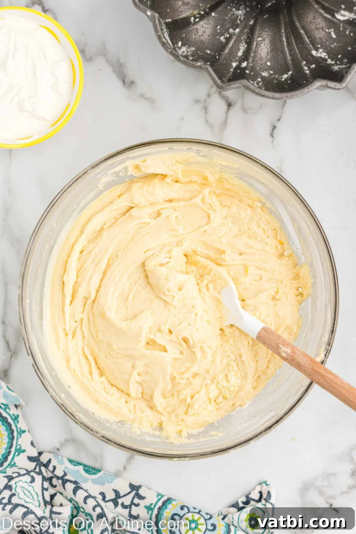 Sour cream thoroughly mixed into the cake batter, creating a smooth and well-blended consistency.