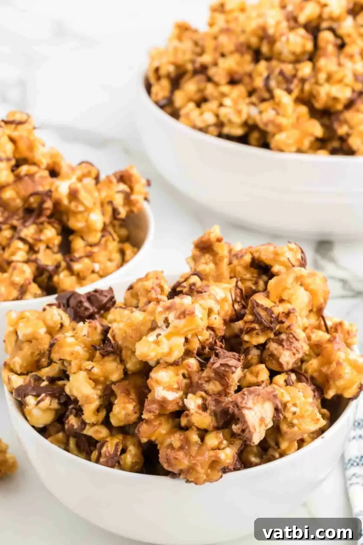 Snickers Popcorn Crunch 2 Snickers popcorn in a bowl, showcasing the caramel, chocolate, and candy bar pieces.