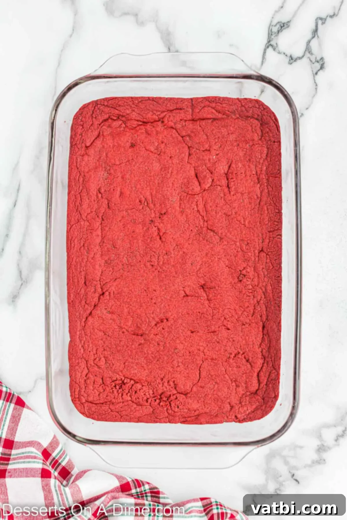 Christmas Layered Dream Dessert 4 The baked red velvet cake mix crust cooling in a 9x13 inch baking pan.