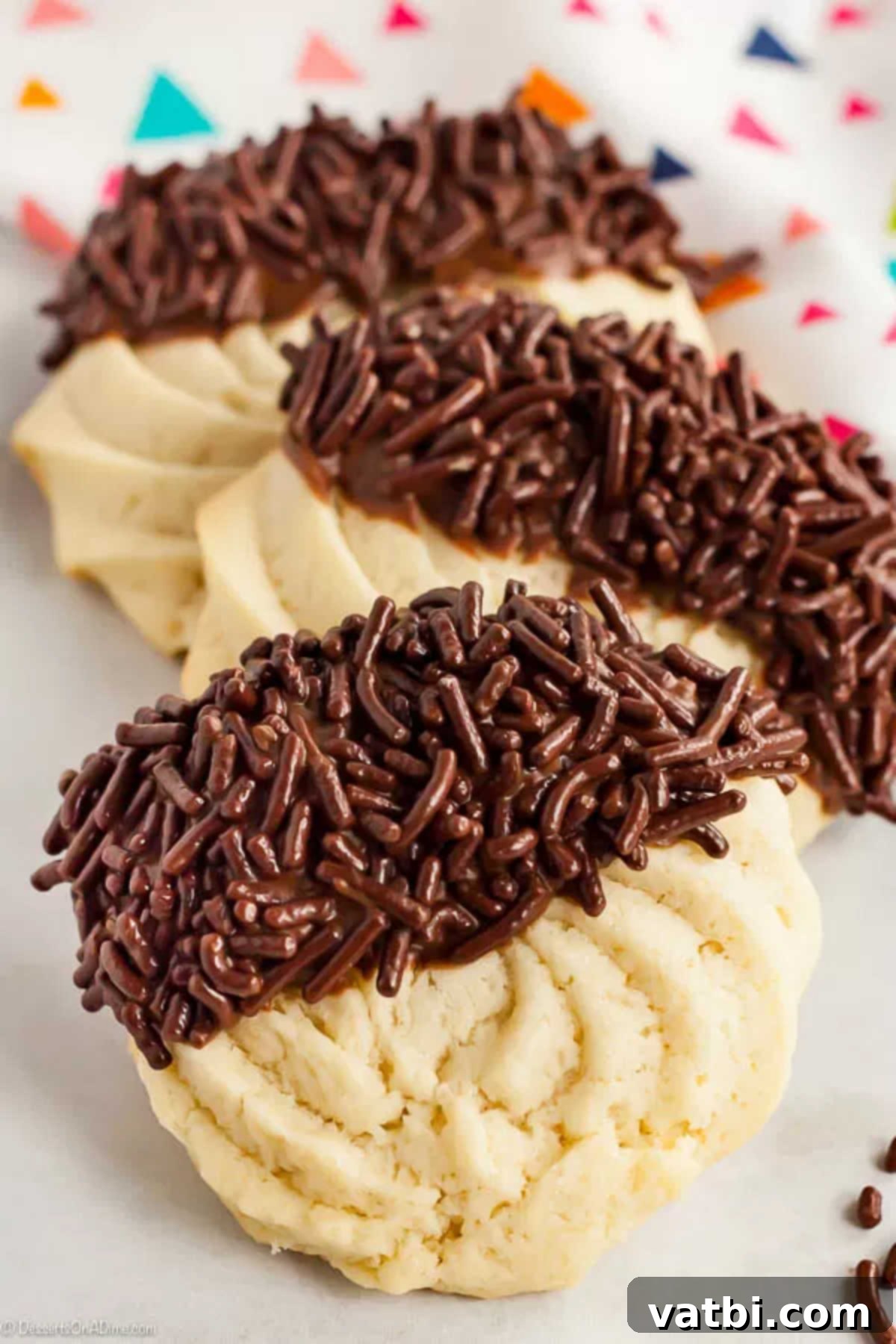 With just a few ingredients, Butter Cookies Recipe comes together quickly for a tasty and gorgeous treat. Easy butter cookies are so pretty and delicious. 2 butter cookies dipped in chocolate frosting and topped with chocolate sprinkles.