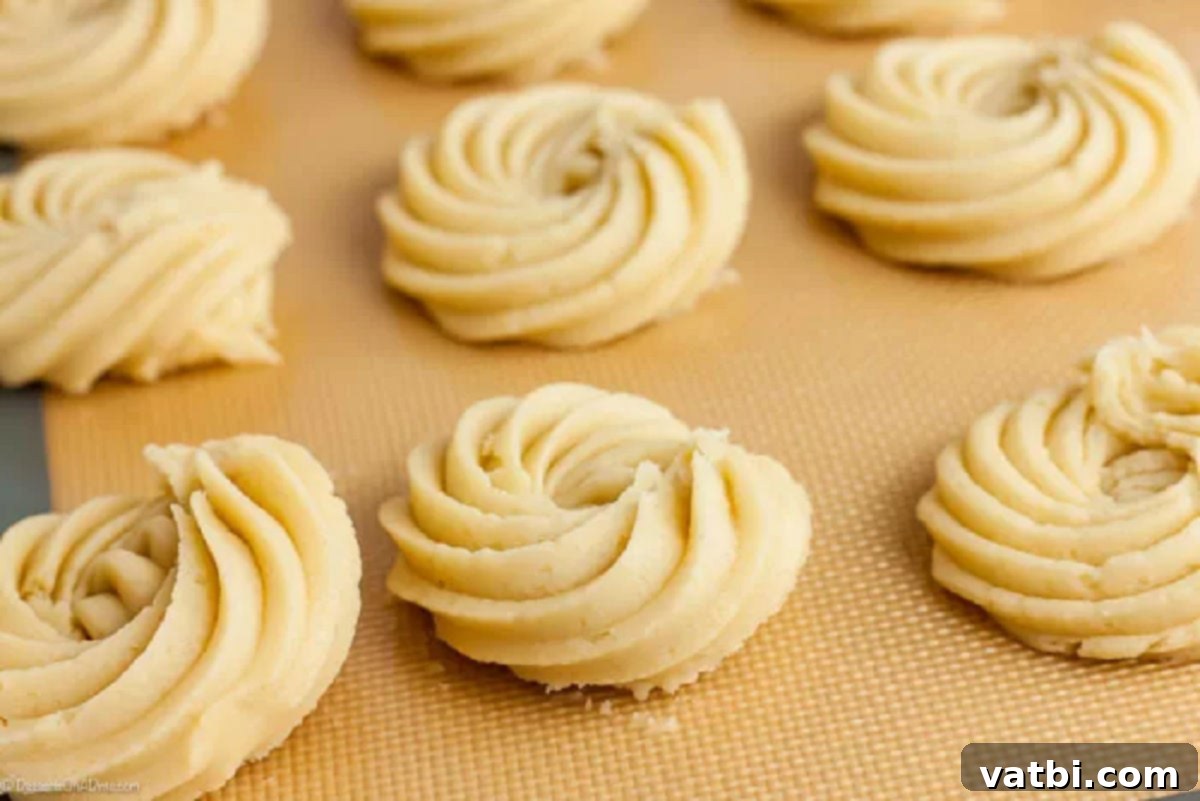 Pure Butter Delights 3 Cookie dough piped on a baking sheet.
