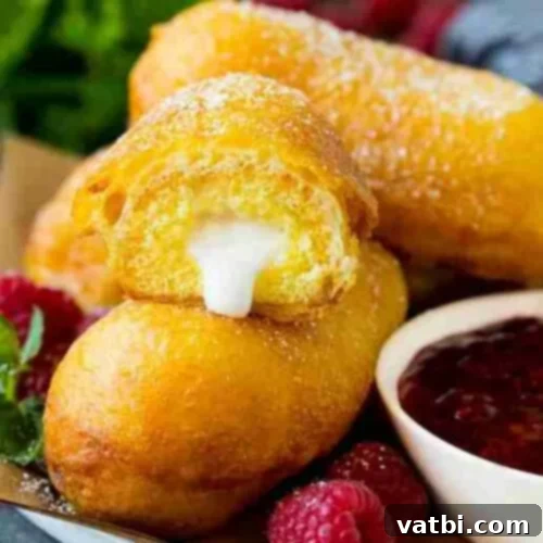 Golden Fried Delights 3 Crispy golden-brown Fried Twinkies, dusted with powdered sugar and served with a vibrant raspberry dipping sauce, transforming a classic snack.