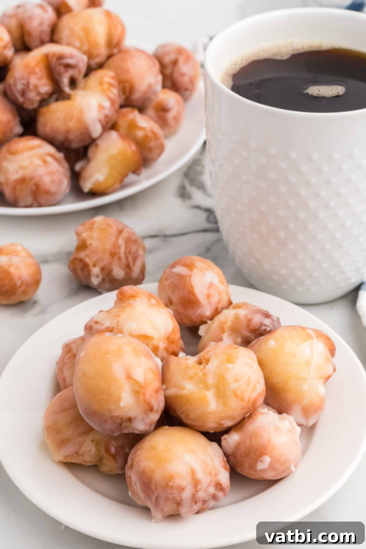 Pop the Sweetness: Krispy Kreme Donut Holes 2 A plate piled high with golden brown, glistening Krispy Kreme Donut Holes, ready to be enjoyed.