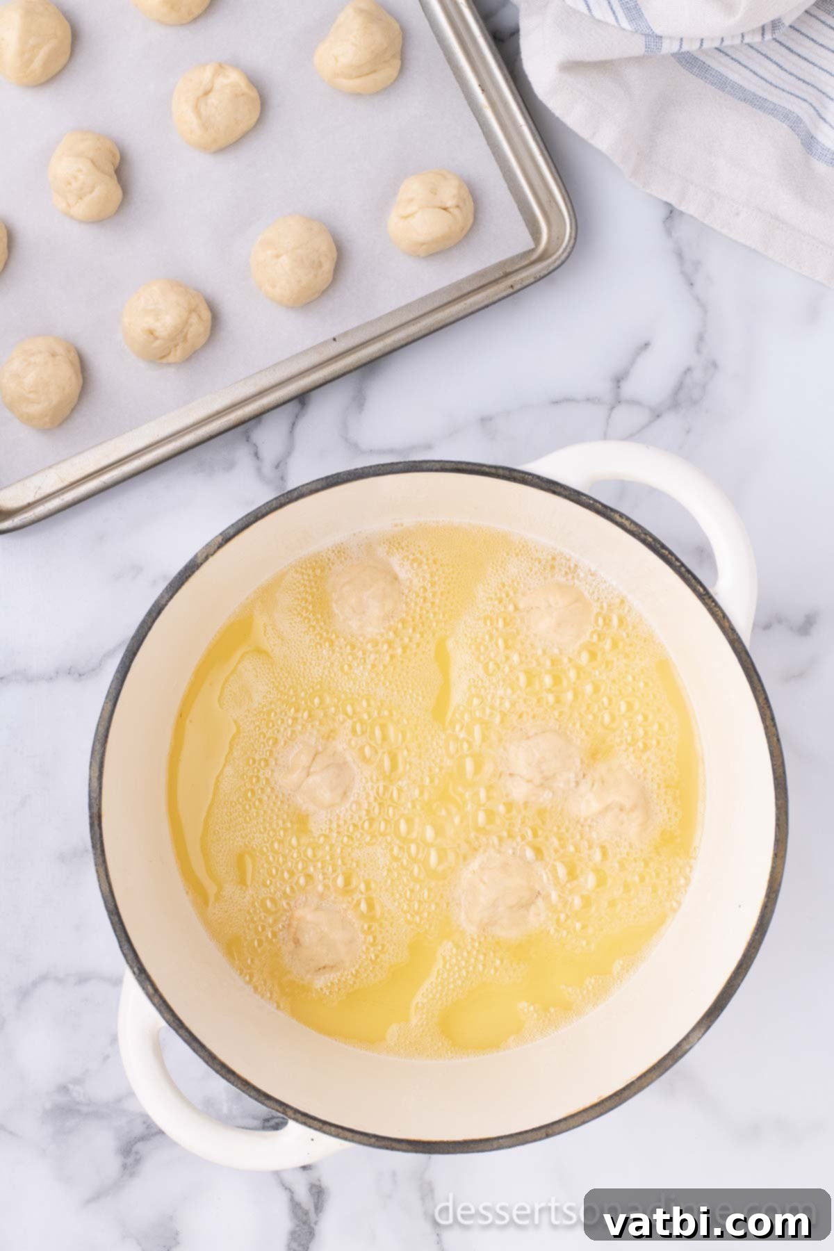 Pop the Sweetness: Krispy Kreme Donut Holes 16 Small balls of donut dough are dropped into hot oil, beginning the frying process to create golden donut holes.