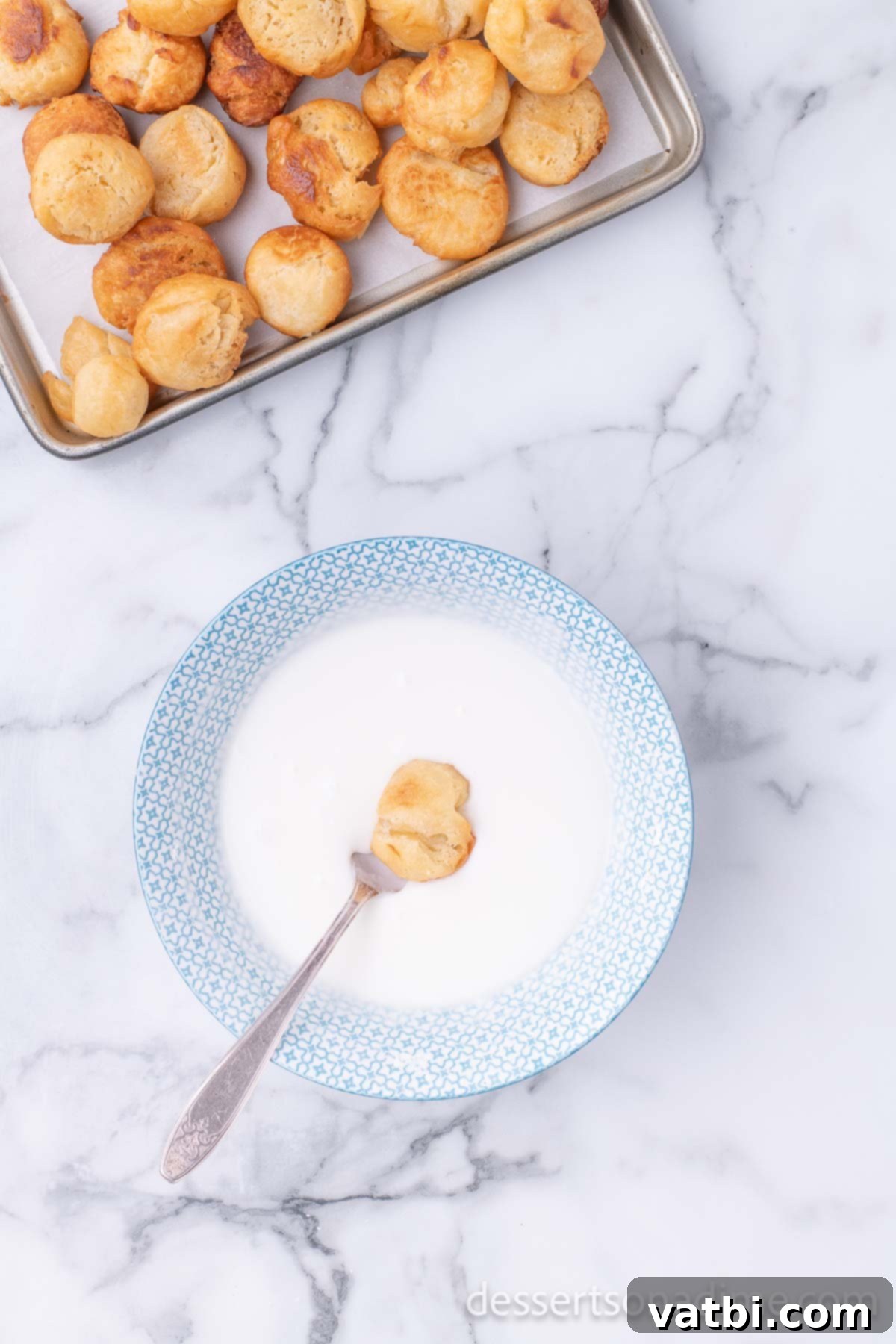 Pop the Sweetness: Krispy Kreme Donut Holes 18 A freshly fried donut hole is dipped into a bowl of warm, sweet glaze, ensuring a perfect coating.