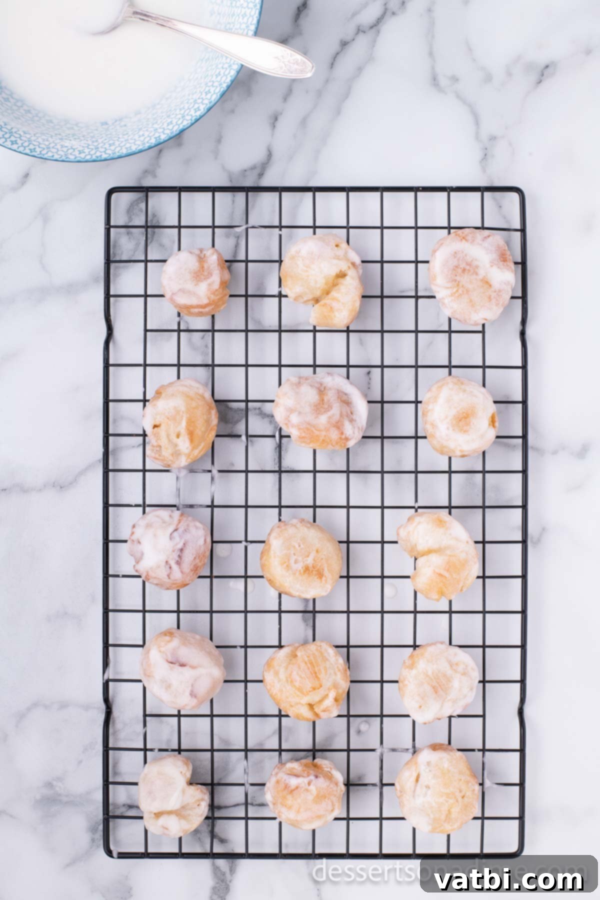 Pop the Sweetness: Krispy Kreme Donut Holes 19 Glazed Krispy Kreme Donut Holes are placed on a wire rack, allowing the sweet glaze to set and cool.