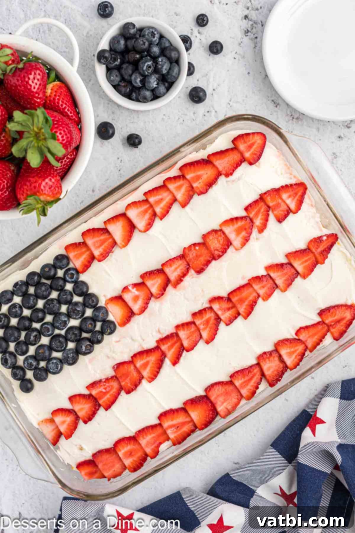Stars and Stripes Dessert 2 American Flag Cake ready to enjoy, topped with fresh blueberries and sliced strawberries forming the iconic flag design.