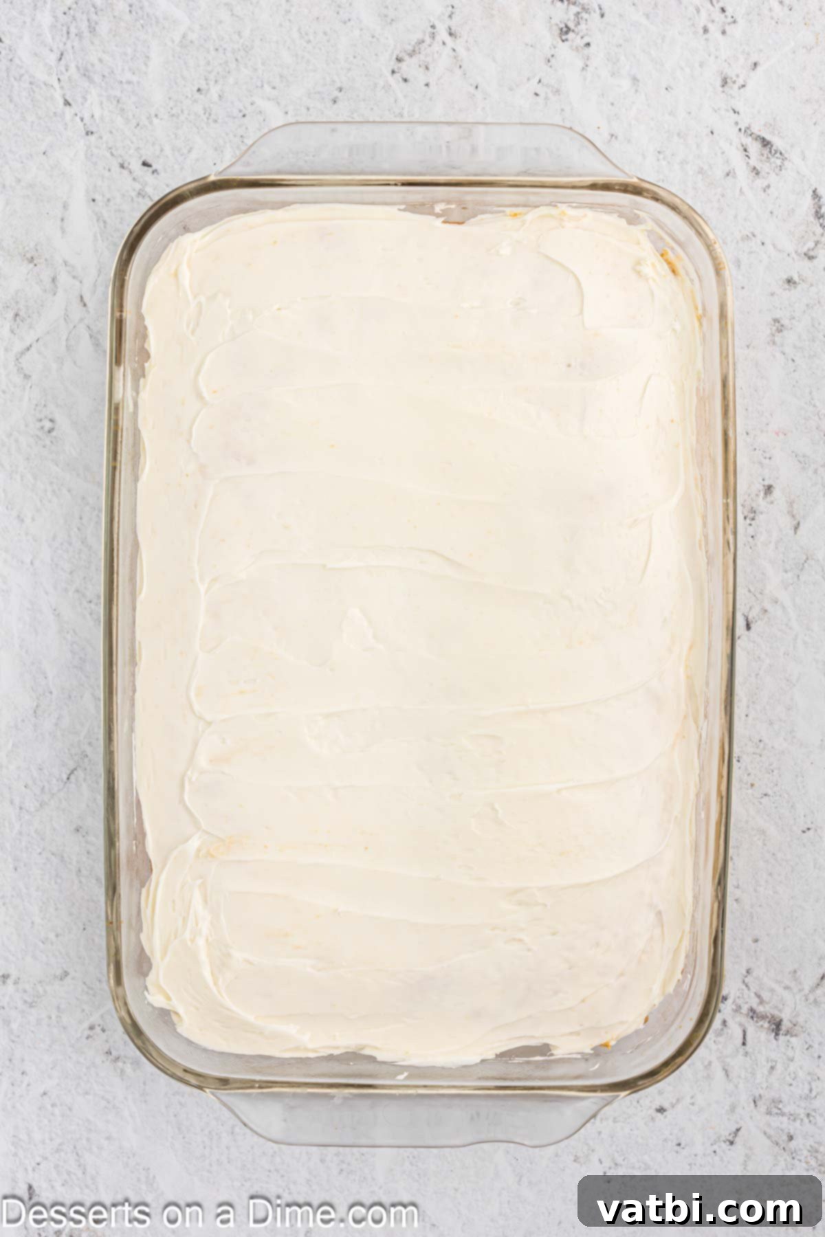 Stars and Stripes Dessert 5 Vanilla icing being spread smoothly over the cooled cake.