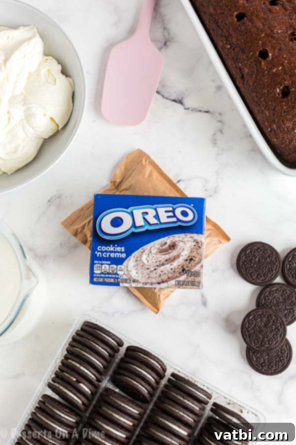 Chocolate and Oreo lovers will go crazy over this Oreo poke cake recipe. This cake is so rich and delicious for the perfect dessert. Plus, it is so easy! Key ingredients laid out for Oreo poke cake including chocolate cake mix, instant Oreo pudding mix, milk, whipped topping, and whole Oreo cookies.
