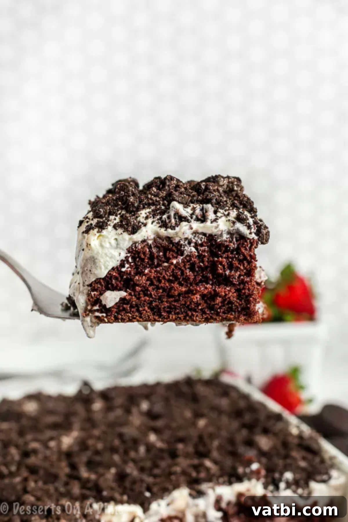 Ultimate Oreo Poke Cake 5 A perfectly sliced piece of Oreo Pudding Cake being lifted from the pan with a spatula, ready to be served and enjoyed.