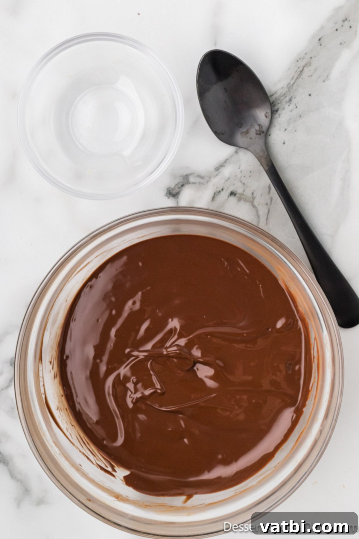 Melted milk chocolate chips and butter in a microwave-safe bowl, ready to be drizzled.