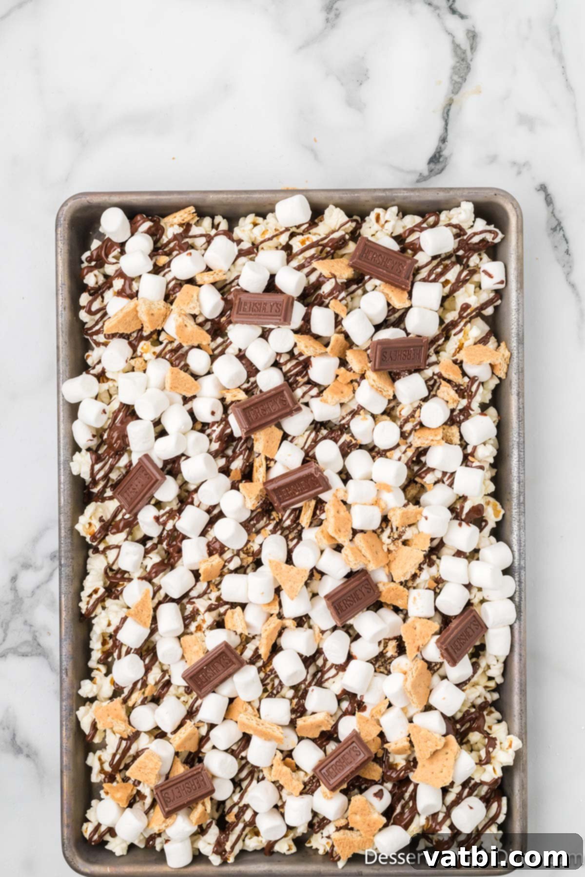 Bite-sized pieces of Hershey's chocolate bar tossed over the S'mores popcorn mixture.
