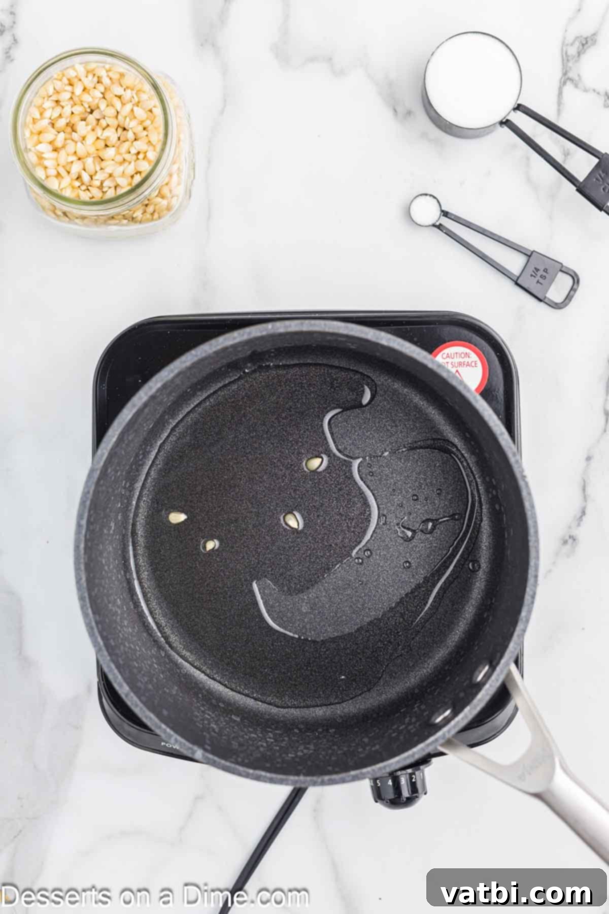 Kettle Popped Perfection 4 Large saucepan with vegetable oil heating on the stovetop.