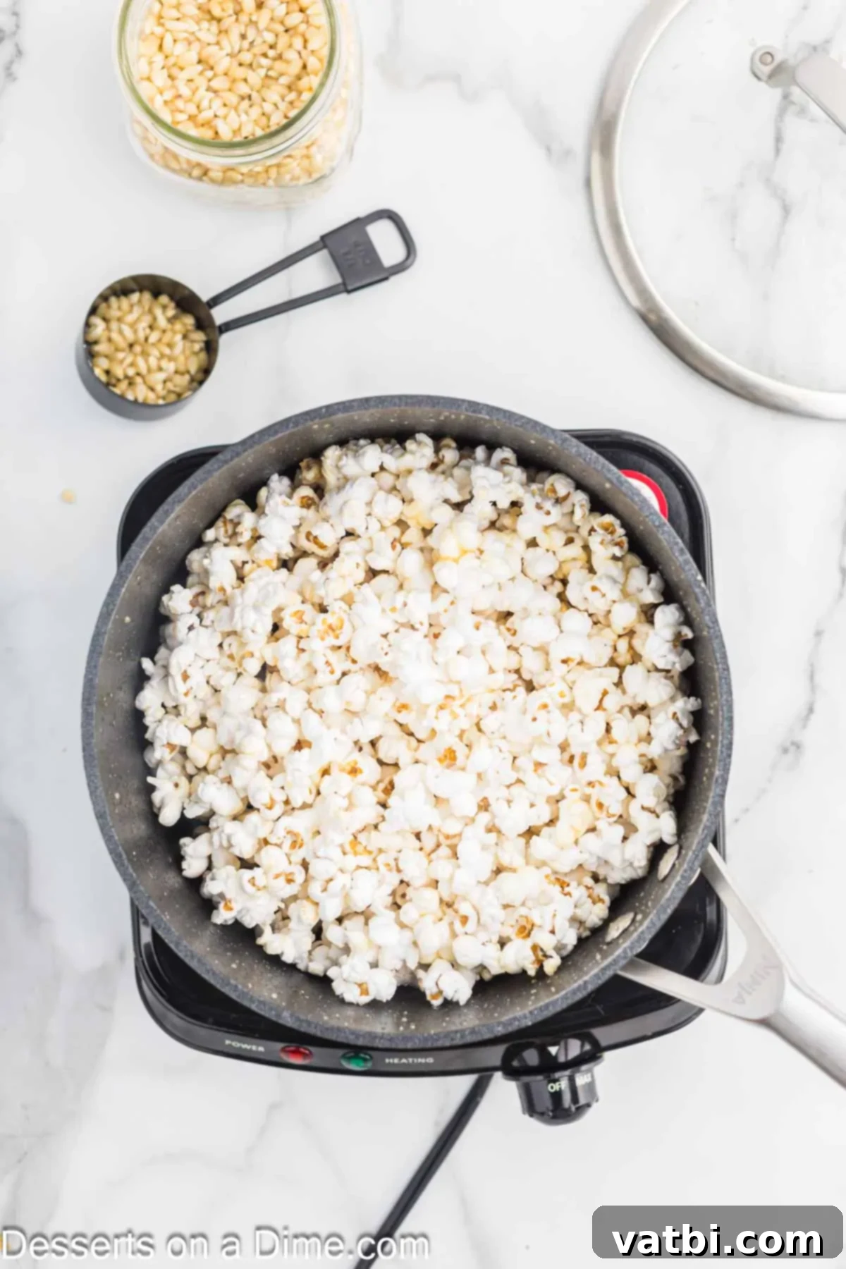 Kettle Popped Perfection 6 Kettle corn popping vigorously in a lidded saucepan on the stove.
