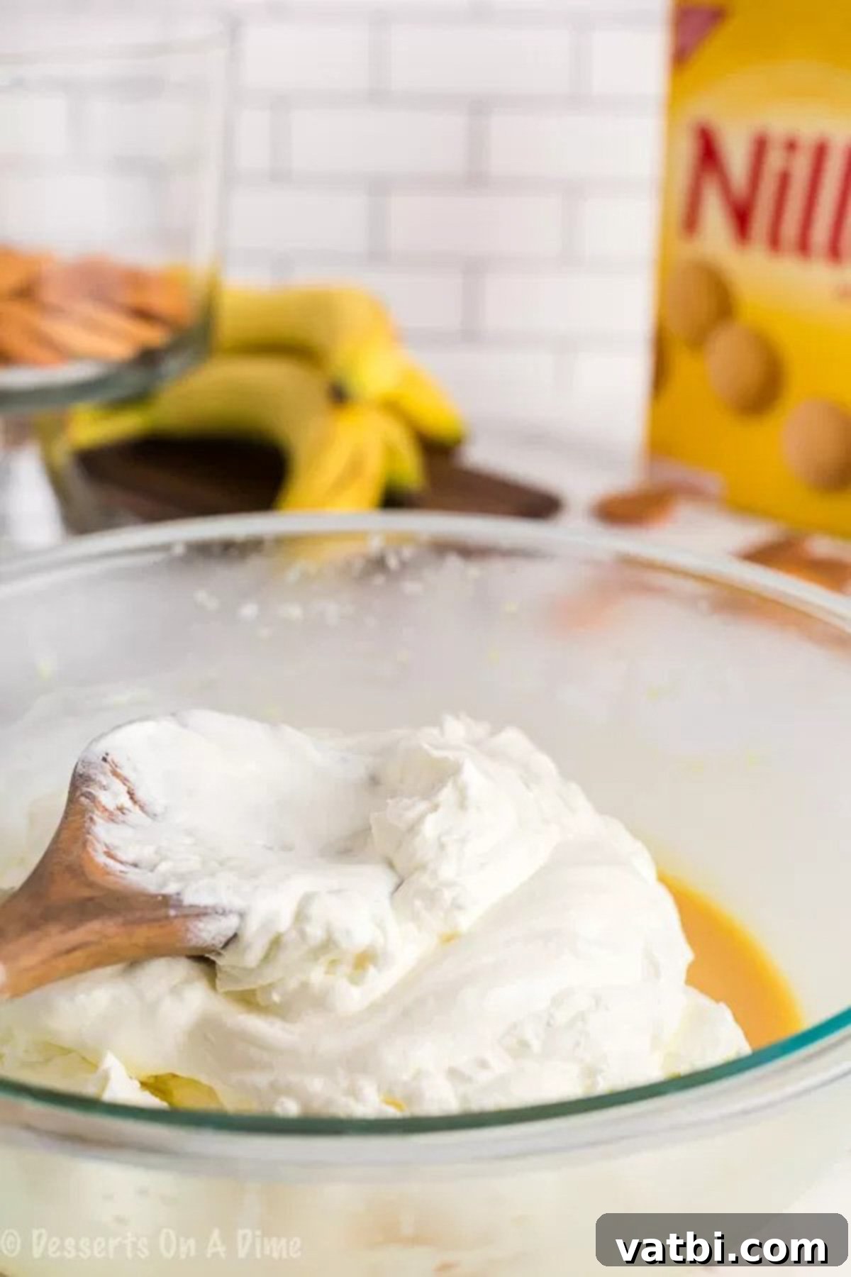 Effortless Banana Pudding Delight 3 Close-up image of whipped cream being gently folded into the pudding mixture.