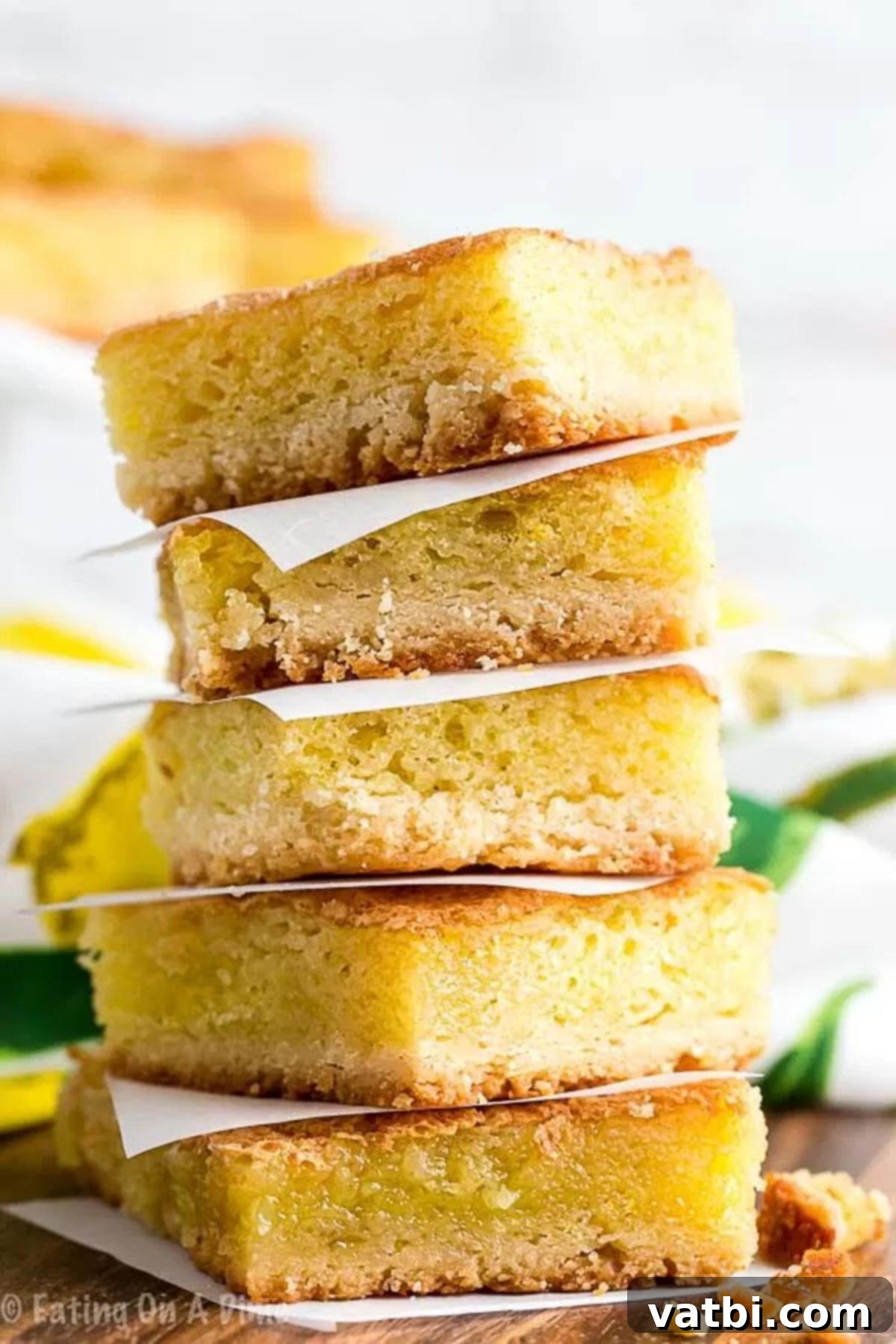 We love all things lemon and this Lemon squares recipe does not disappoint. It is sweet and tangy for the best dessert. Oh and that yummy powdered sugar! Close up image of Lemon squares stacked