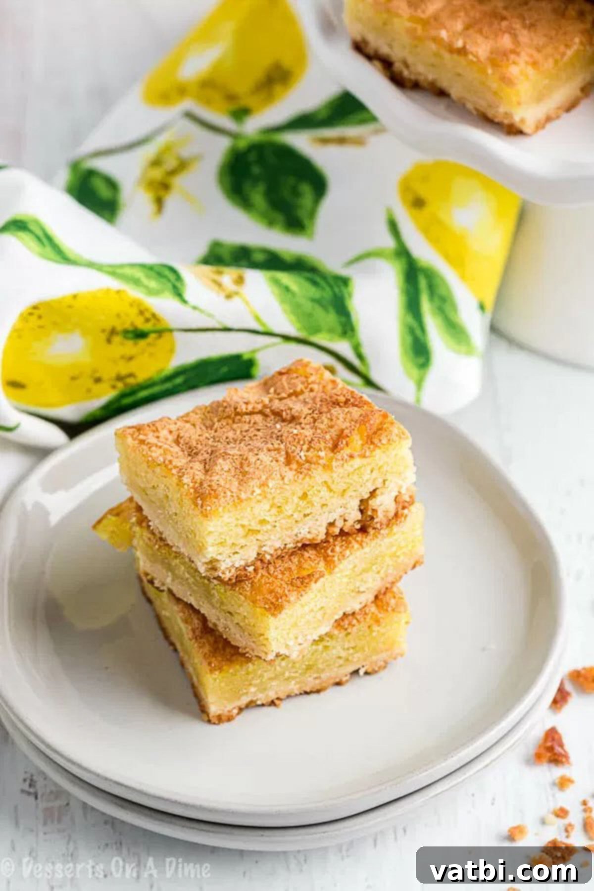 We love all things lemon and this Lemon squares recipe does not disappoint. It is sweet and tangy for the best dessert. Oh and that yummy powdered sugar! Close up image of Lemon squares stacked on a white plate