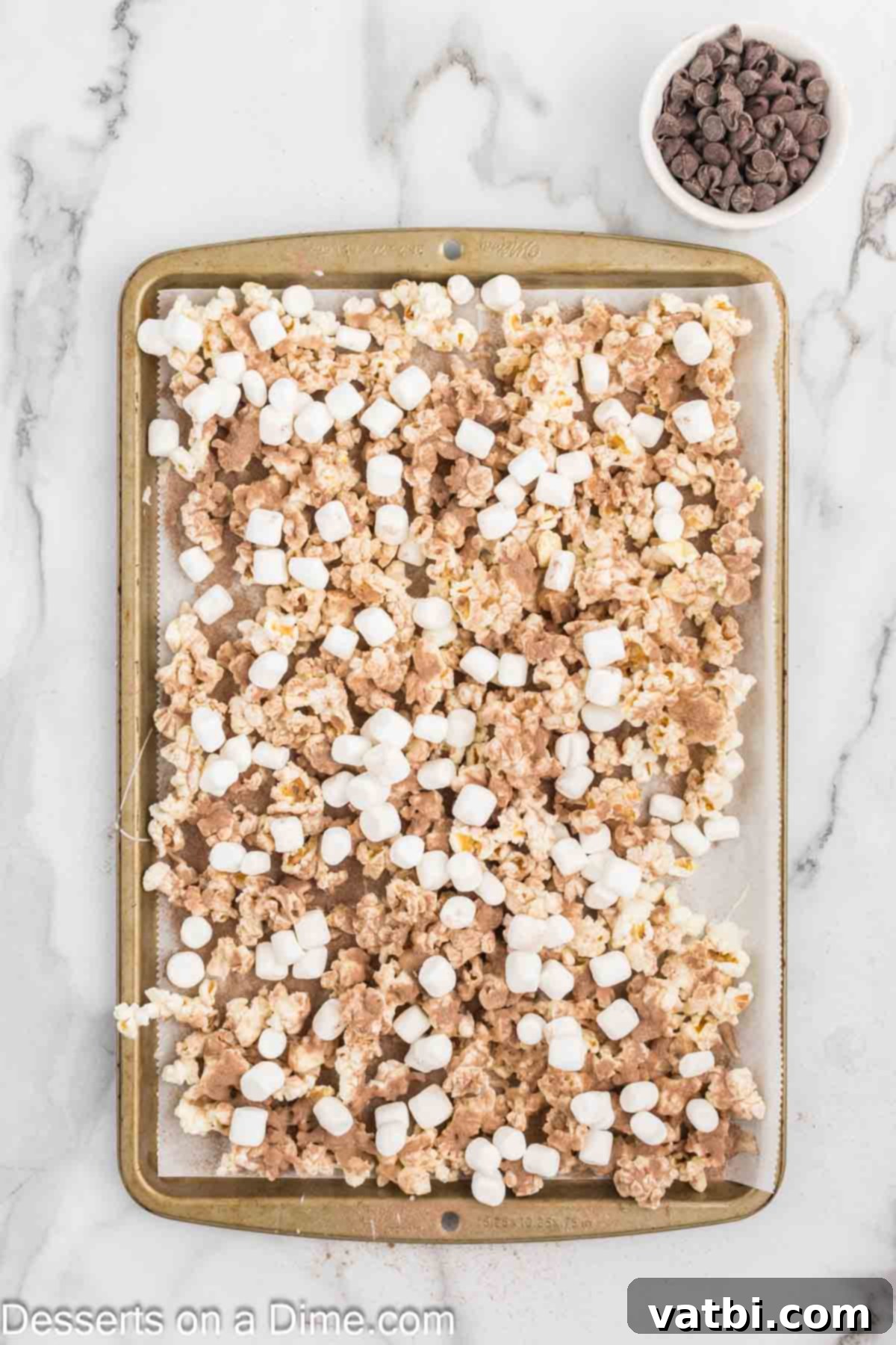 Velvet Chocolate Popcorn 8 Marshmallows sprinkled on top of popcorn.