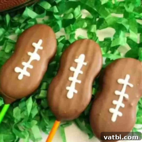 55 Winning Super Bowl Desserts 4 Football cookie pops decorated with white icing laces.