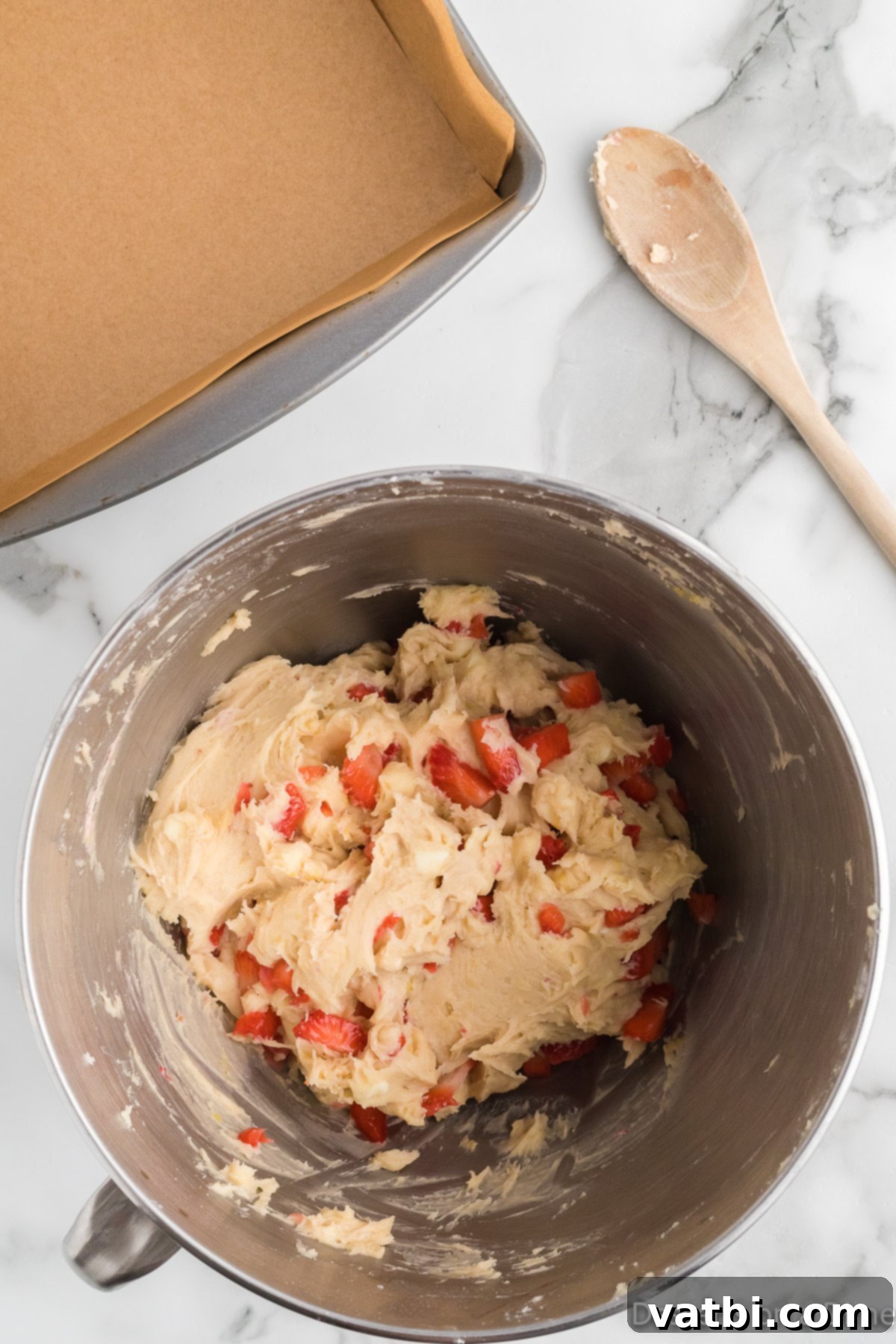 Zesty Strawberry Lemon Blondie Delight 8 Diced fresh strawberries and white chocolate chips being folded into the blondie batter.