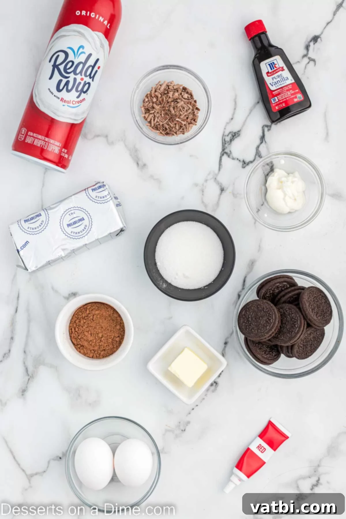 Ingredients for Mini red velvet cheesecake - oreo cookies, butter, cream cheese, sour cream, cocoa powder, vanilla, red food coloring, whipped cream, chocolate shavings.