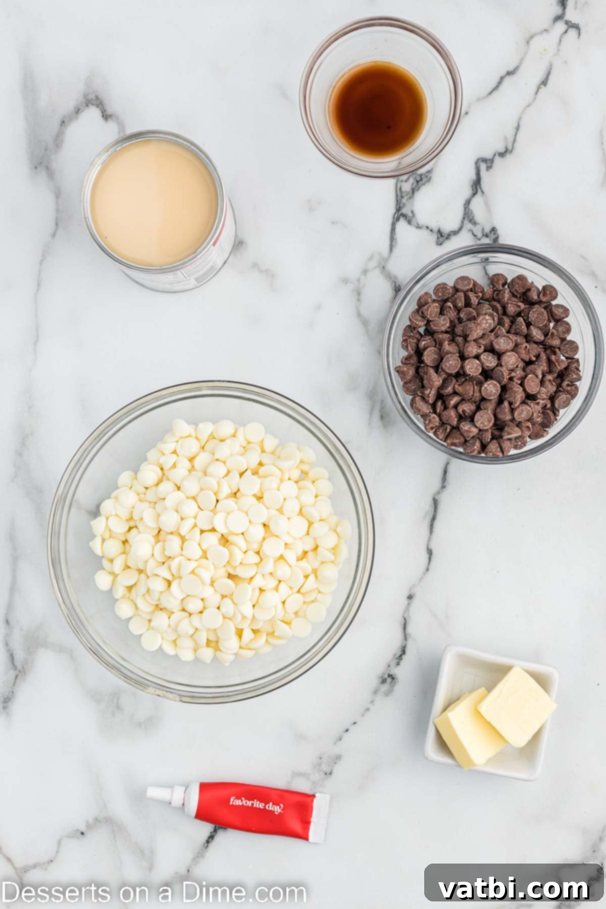Decadent Red Velvet Fudge 3 A collection of ingredients for Red velvet fudge including white chocolate chips, sweetened condensed milk, butter, vanilla extract, and red food coloring, neatly arranged on a white surface.