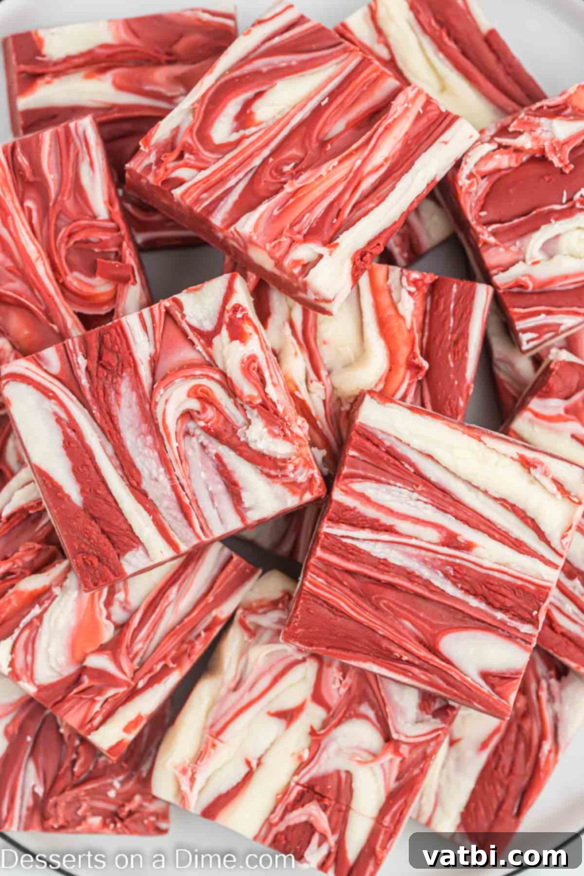 Decadent Red Velvet Fudge 10 Stack of red velvet fudge squares, showing off the intricate swirls and rich color, ready for serving.