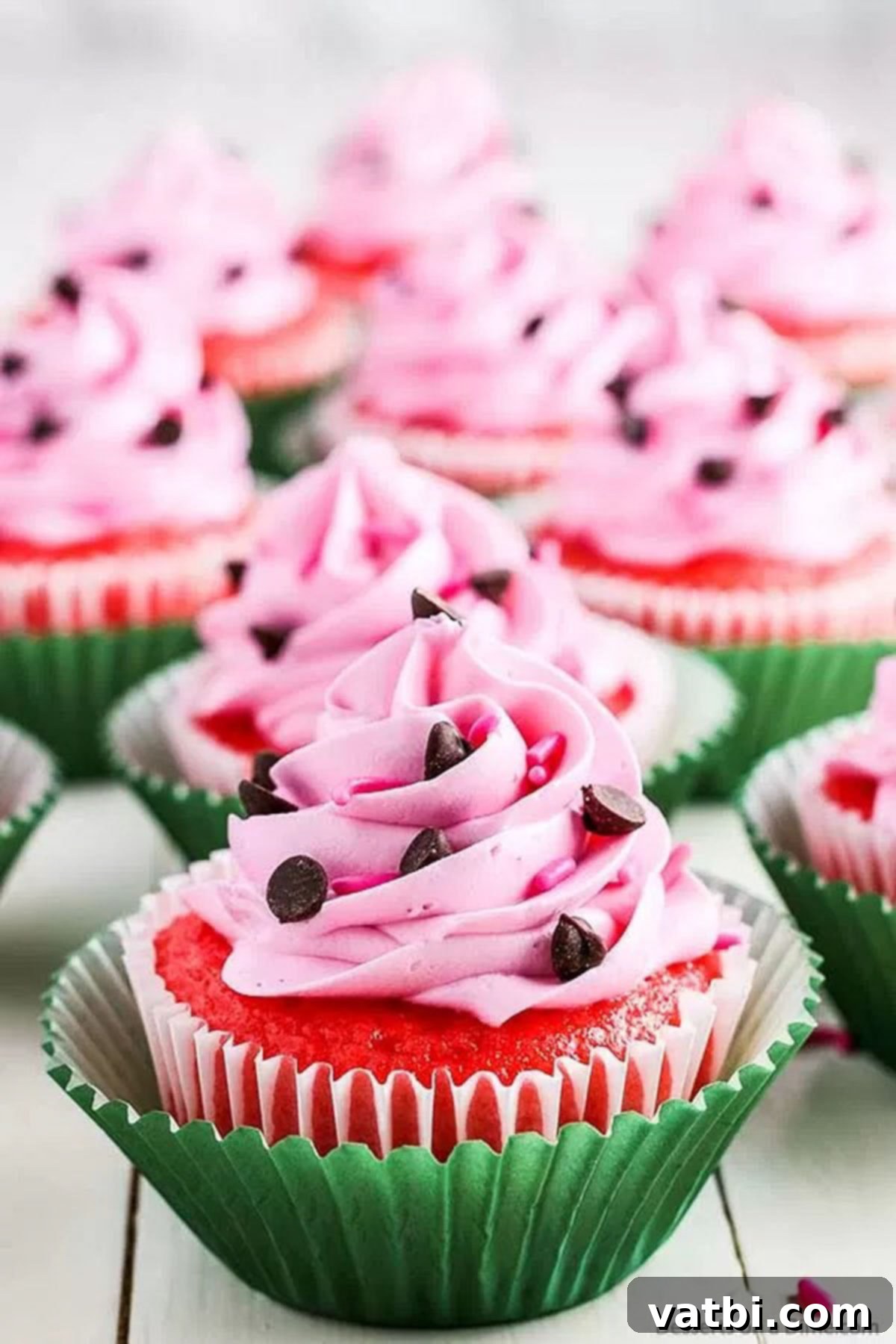 Easy Watermelon Cupcakes: The Perfect Summer Dessert Vibrant pink watermelon cupcakes decorated with chocolate chips, ready to be served at a summer party.