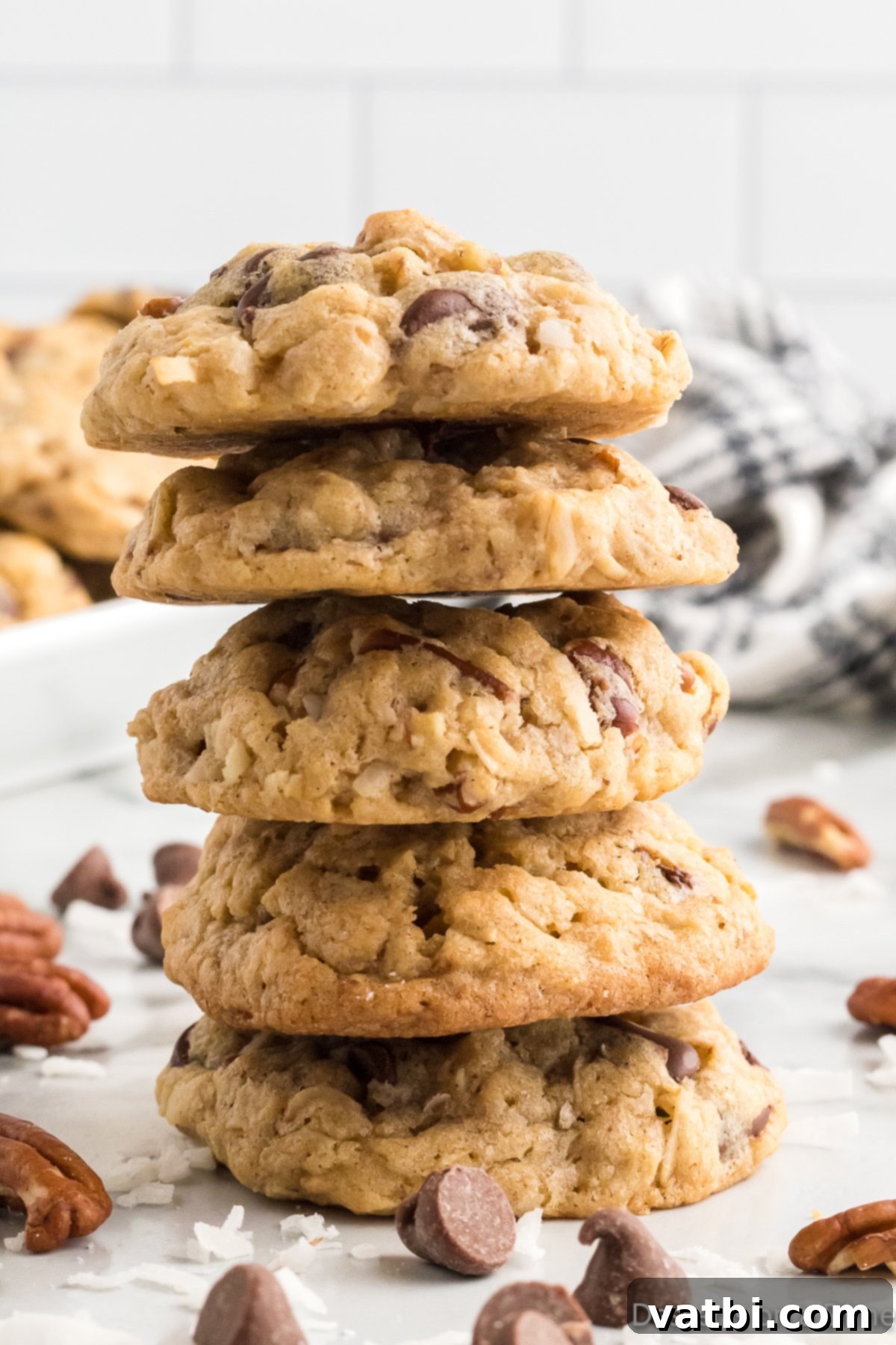 Loaded Cowboy Cookies 12 A close-up shot of several Cowboy cookies stacked, highlighting their texture and ingredients like oats, chocolate, and pecans.