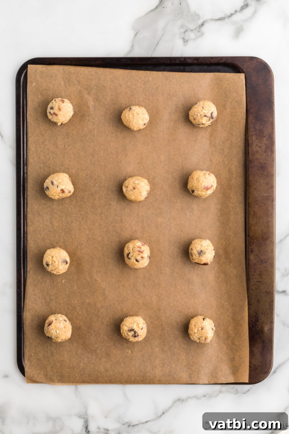 Loaded Cowboy Cookies 9 Uniform cookie dough balls scooped onto a baking sheet lined with parchment paper.