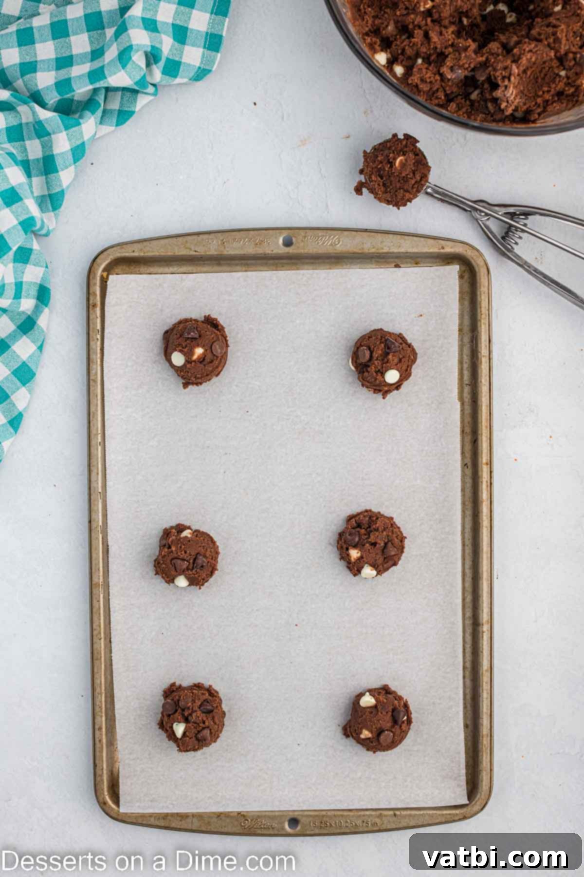 Decadent Triple Chocolate Cookies 9 Cookie dough scooped into balls and placed on a baking sheet, topped with additional chocolate chips.