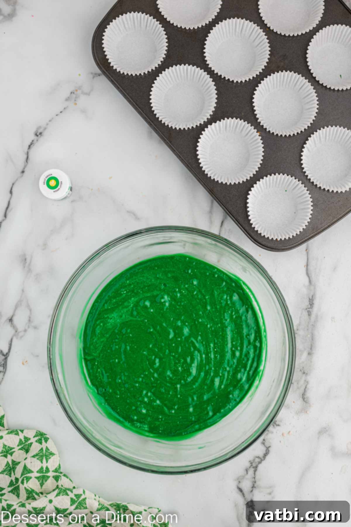 Lush Green Velvet Cupcakes 9 Fluffy, beaten egg whites being gently folded into the green cupcake batter in a mixing bowl.
