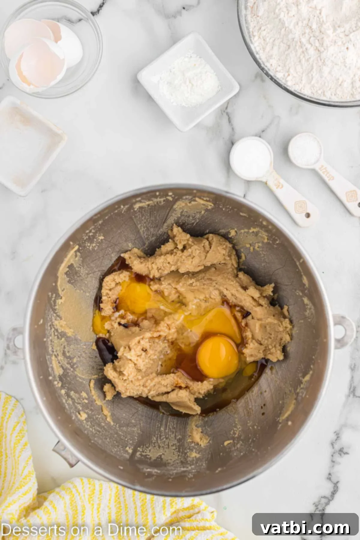 Mixing bowl with softened butter, granulated sugar, and brown sugar being creamed together.