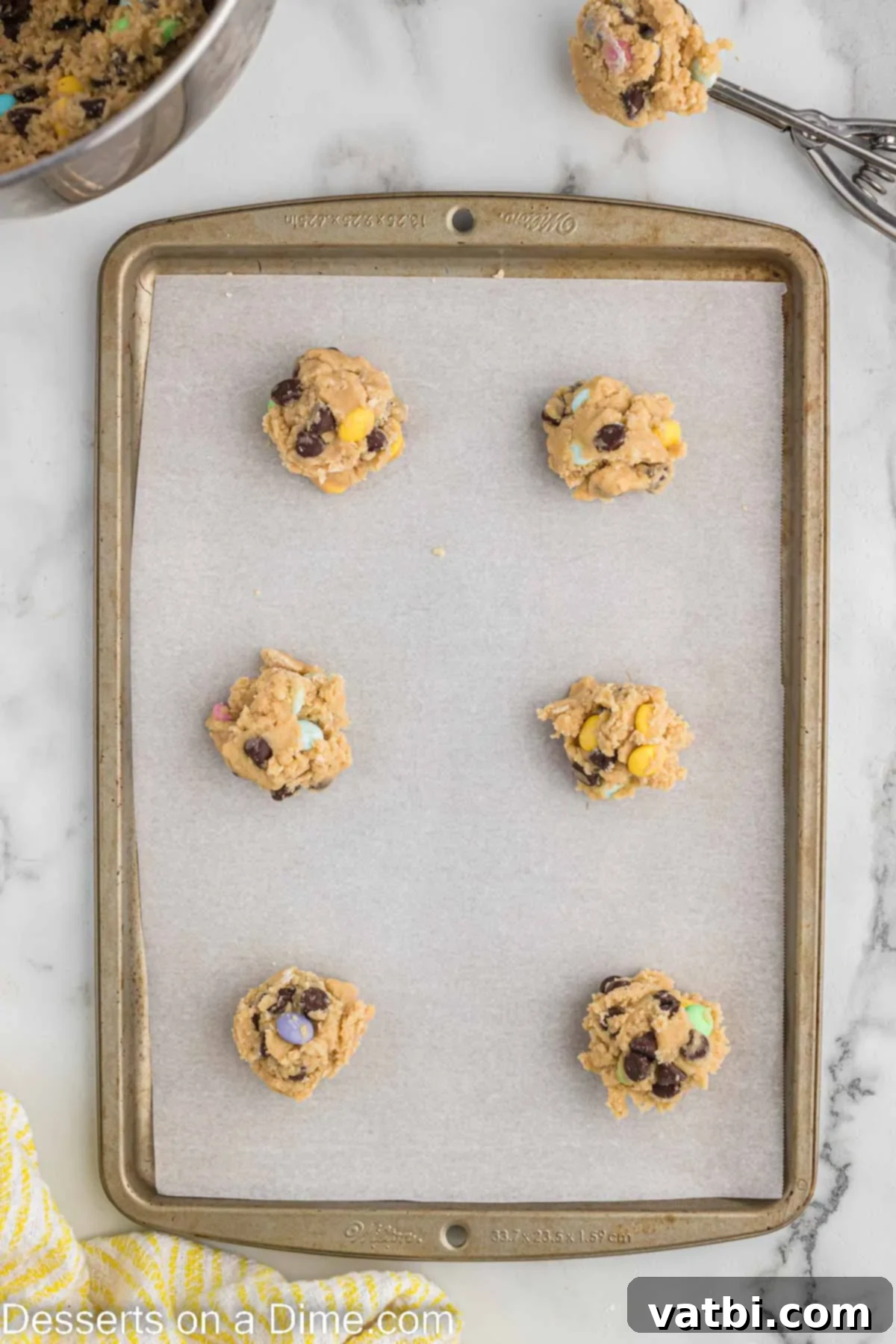 Scooped cookie dough balls placed on a baking sheet, ready for the oven.