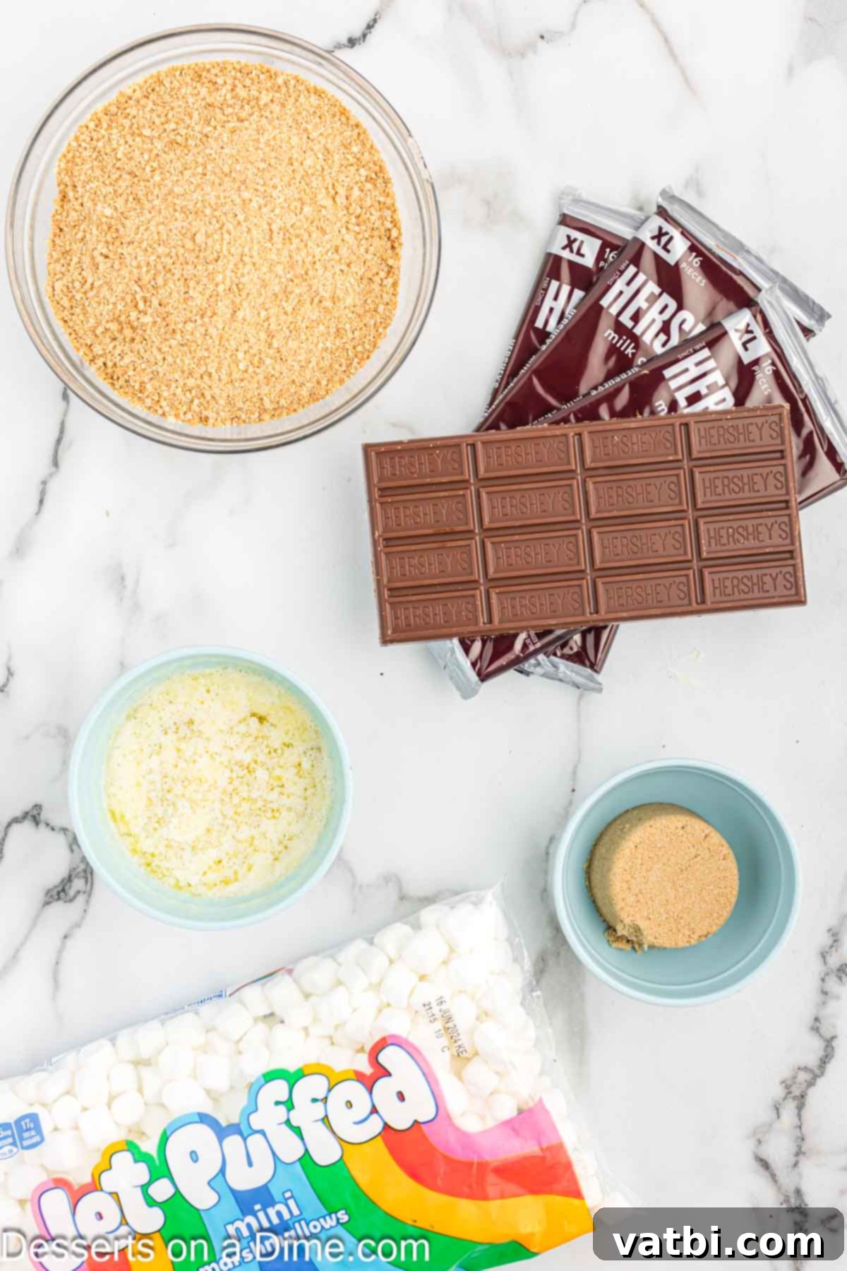 Gooey Smores Treat 3 Key ingredients for S'mores Bars: graham cracker crumbs, mini marshmallows, brown sugar, butter, and Hershey's chocolate bars.